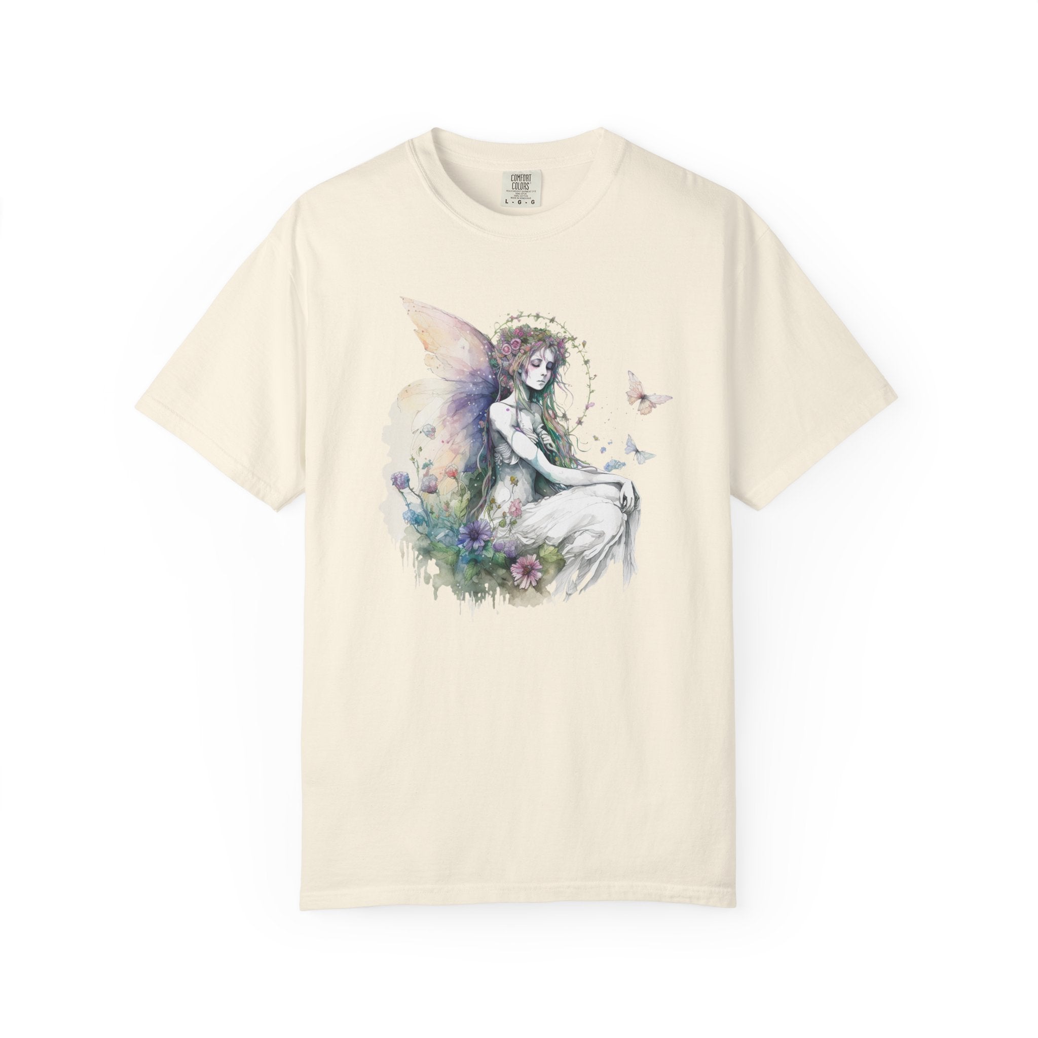 An off-white short-sleeve crewneck t-shirt featuring a watercolor-style graphic of a fairy with wings and flowers on the front, displayed against a solid white background.
