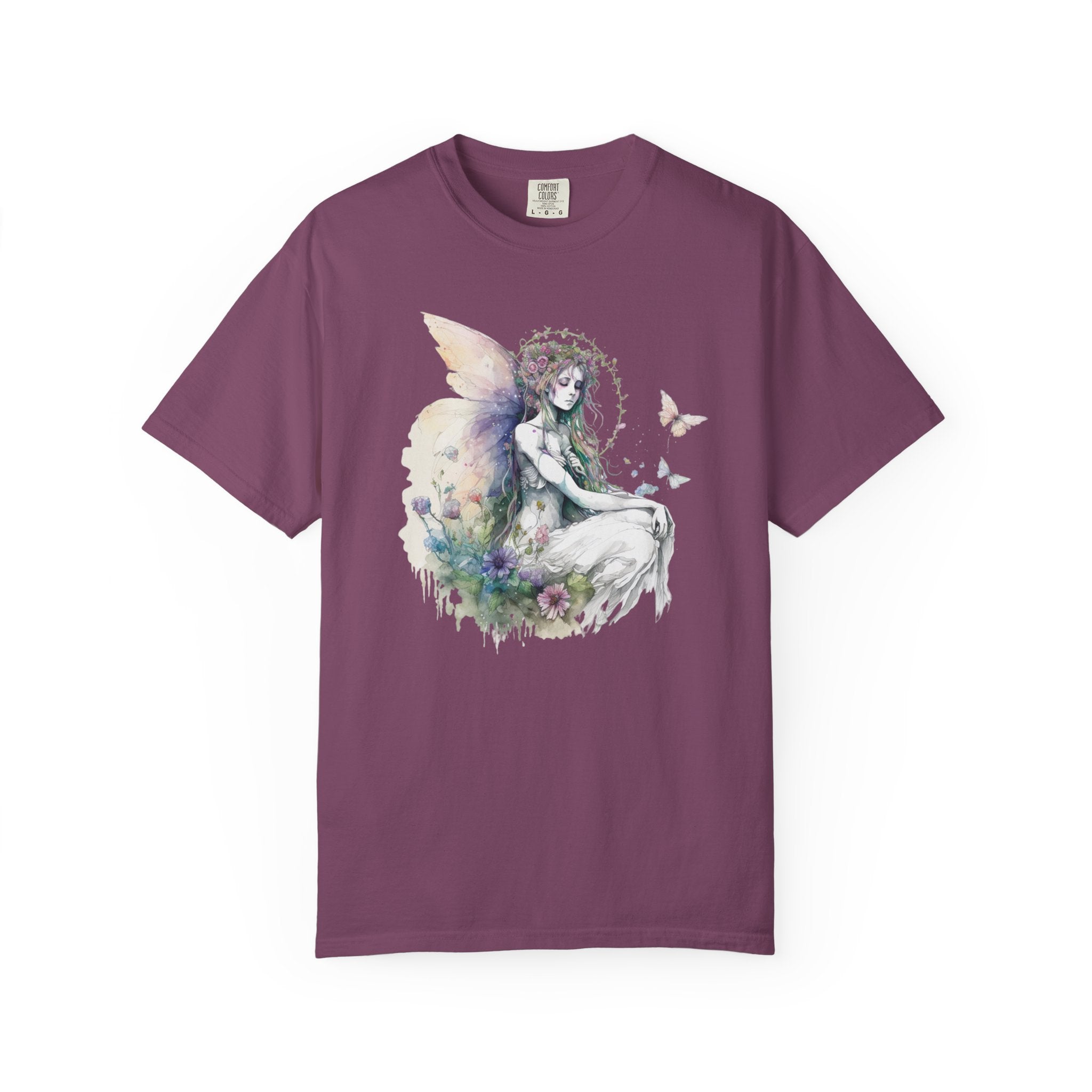 A short-sleeve crewneck t-shirt in a muted plum purple color, featuring a central graphic print of a fairy with pastel wings and butterflies.