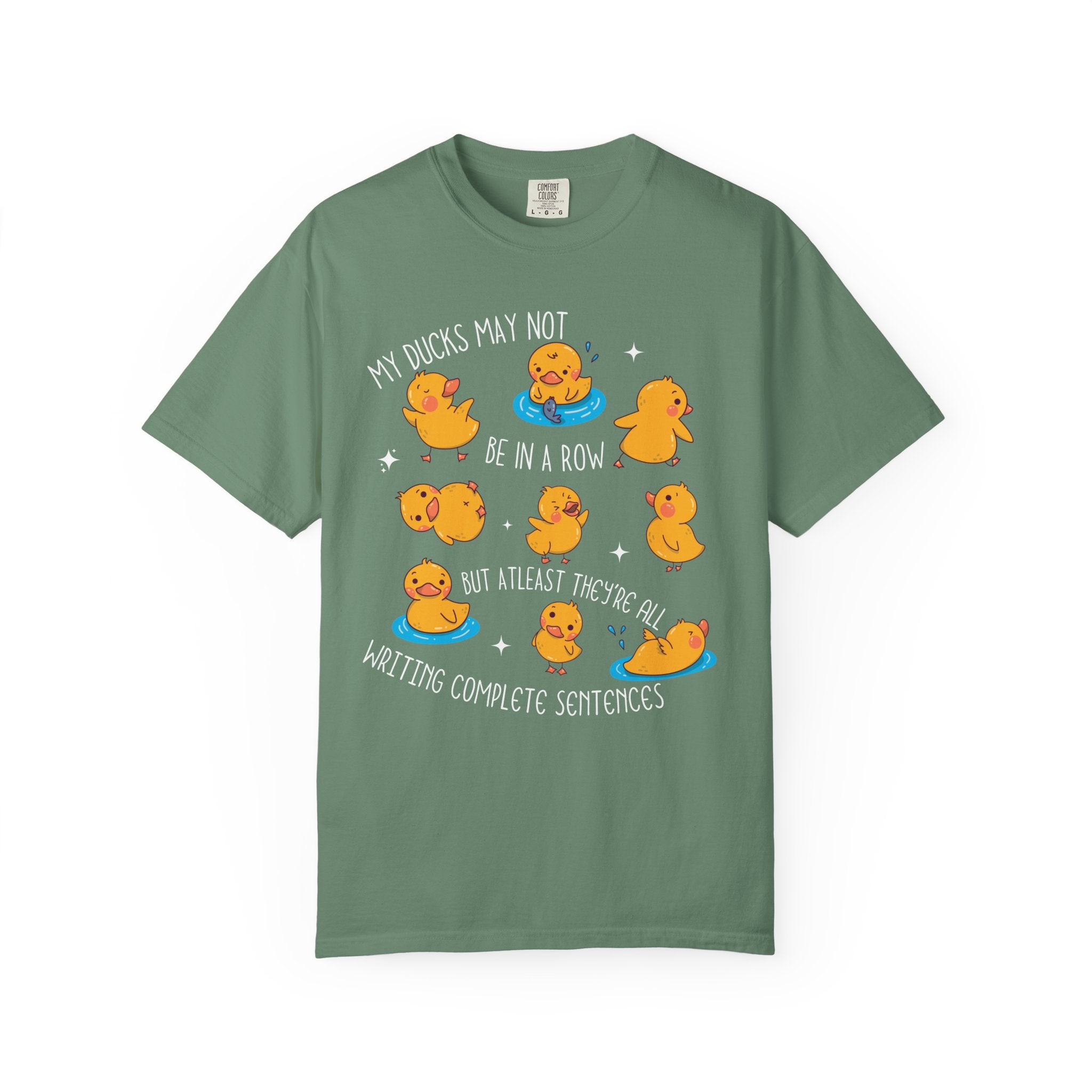 Playful duck illustration with the phrase ‘My ducks may not be in a row, but at least they’re all writing complete sentences,’ designed as a humorous shirt for English teachers.