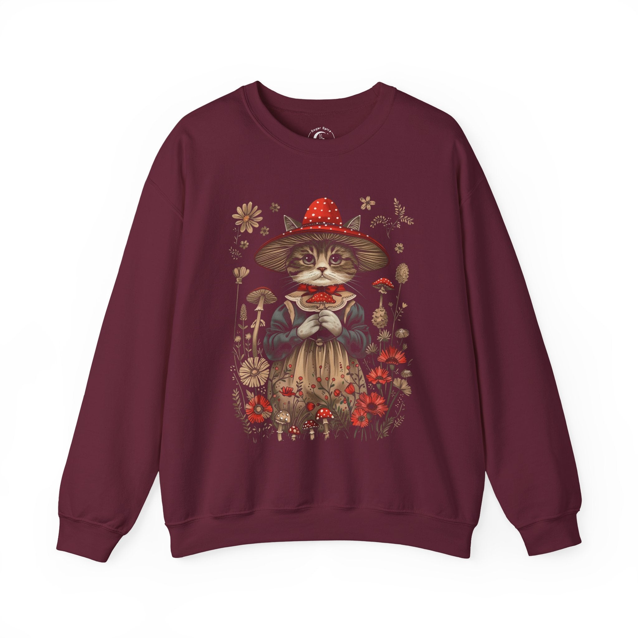 Cottagecore cat sweatshirt with whimsical cat in red mushroom witch hat and vintage dress surrounded by wildflowers and toadstools.