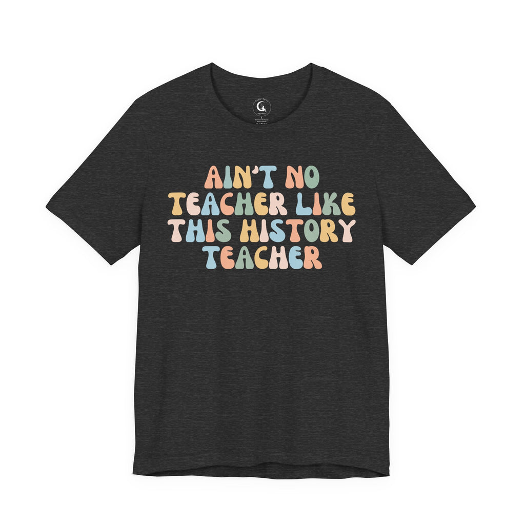 A dark heather gray short-sleeve t-shirt with a retro-style multicolor text graphic reading 'AIN'T NO TEACHER LIKE THIS HISTORY TEACHER' on the front, displayed against a solid white background.