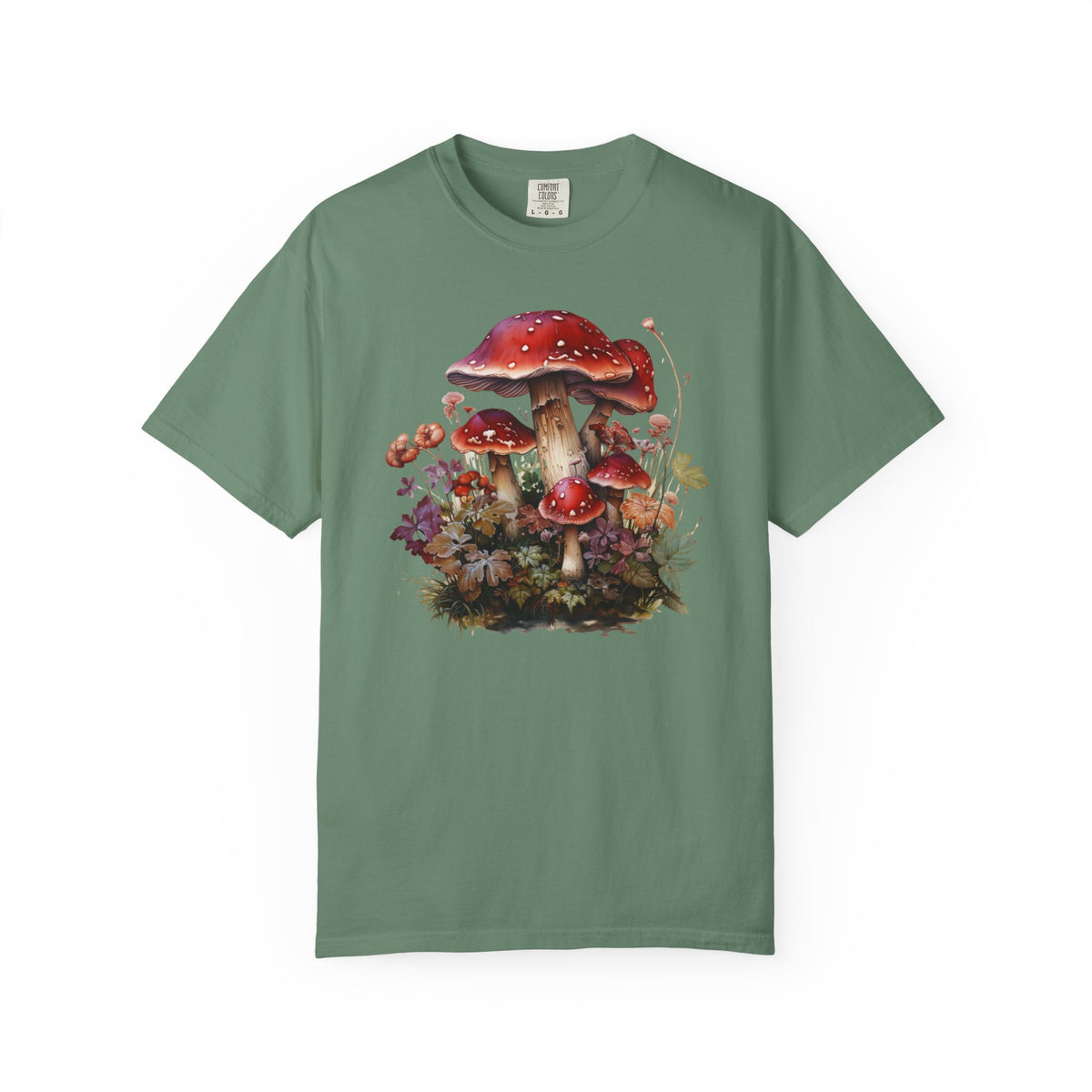 A sage green short-sleeve crewneck t-shirt featuring a detailed graphic print of red-capped mushrooms, moss, and small orange flowers on the front, displayed against a solid white background.
