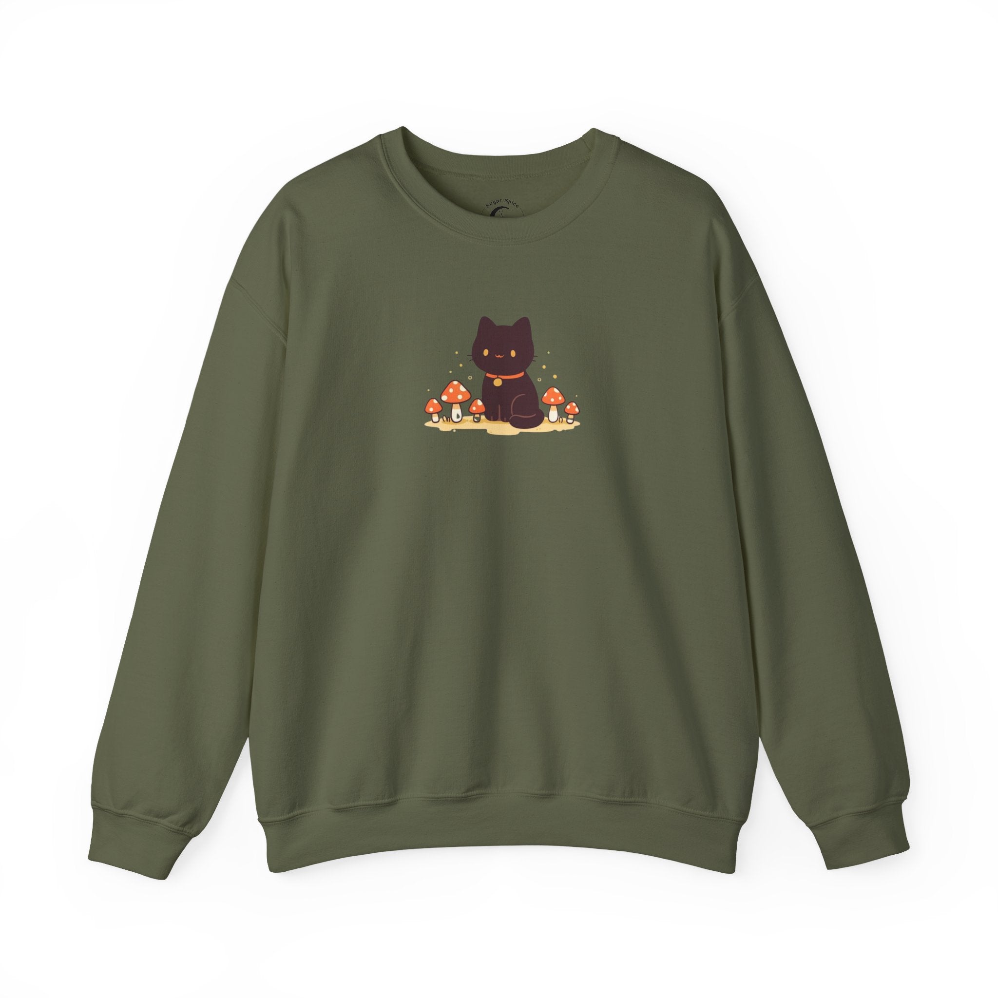 A cozy Comfort Colors sweatshirt featuring a cute black cat sitting among red mushrooms, perfect for cottagecore and witchy aesthetic lovers.