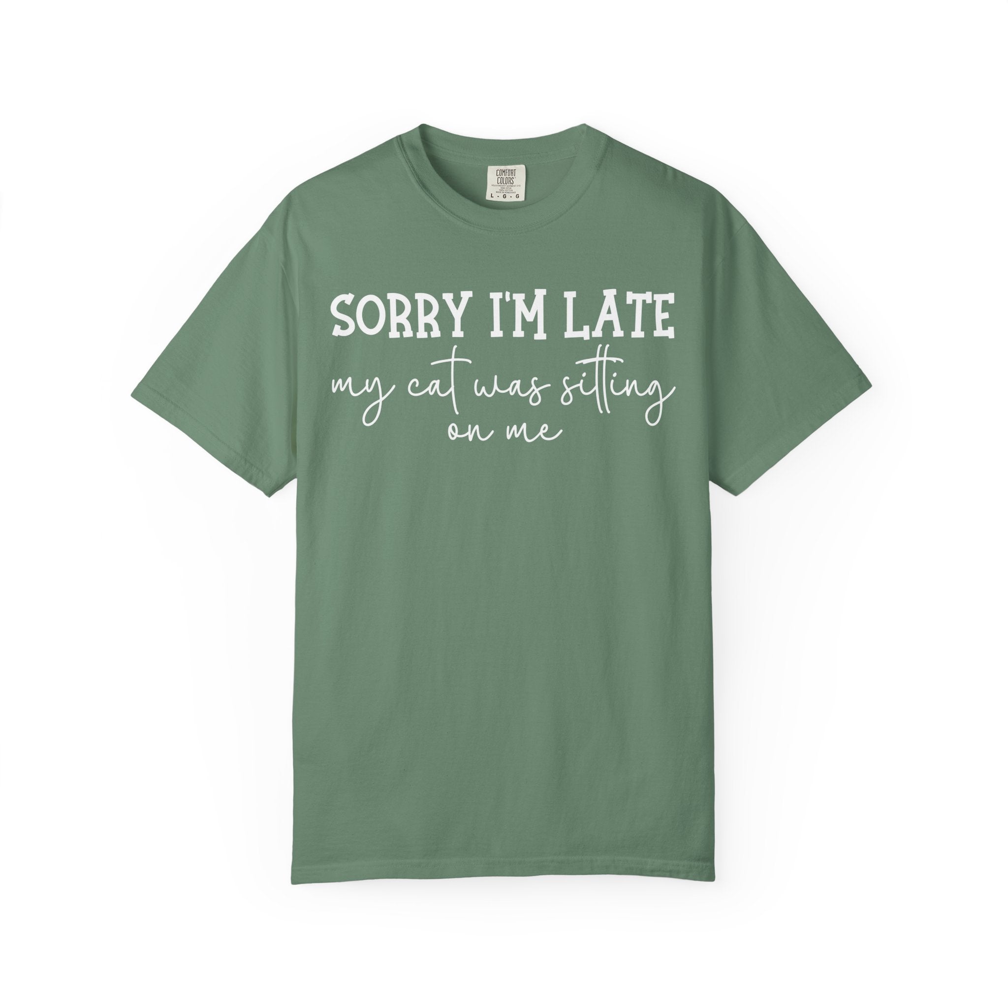 Funny cat lover graphic t-shirt featuring the quote "Sorry I'm Late My Cat Was Sitting on Me." A humorous gift for cat moms, cat dads, and anyone owned by a sleepy cat.