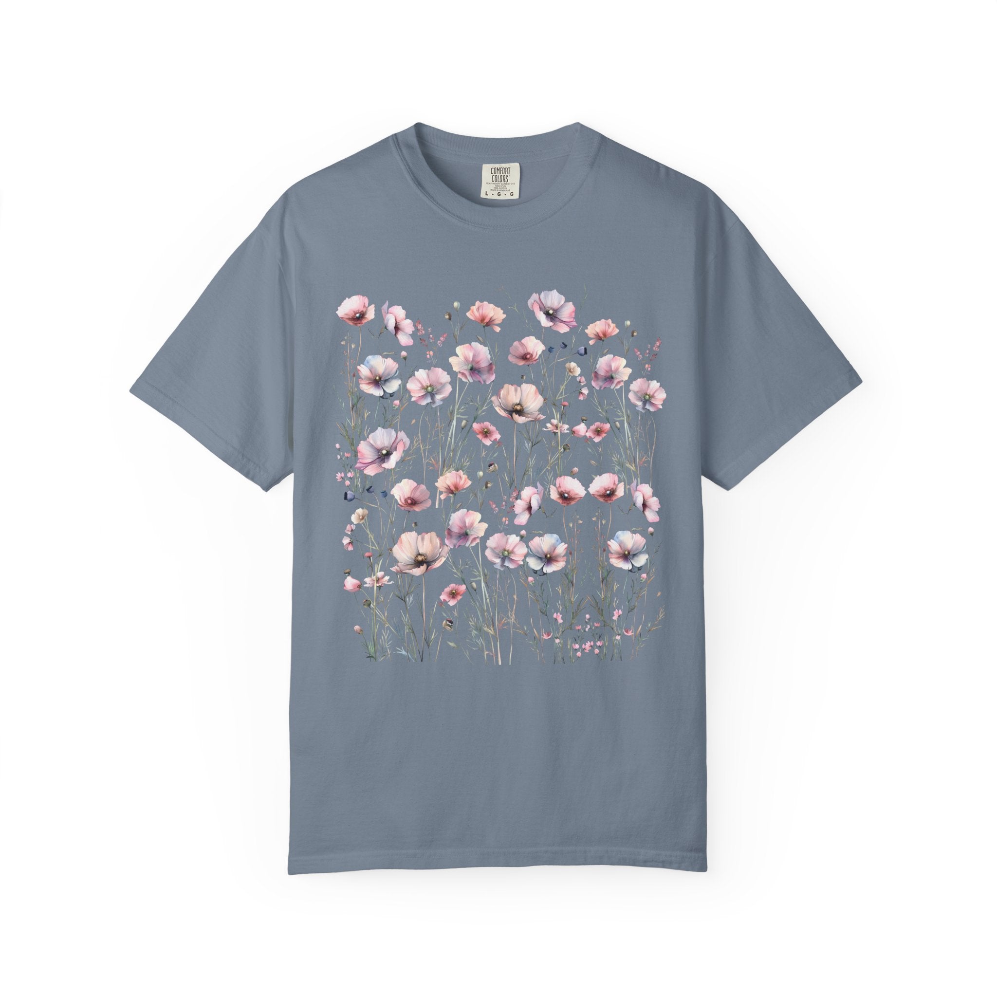 Delicate pastel wildflowers and soft pink blossoms arranged in a meadow pattern on a vintage Comfort Colors cottagecore shirt.