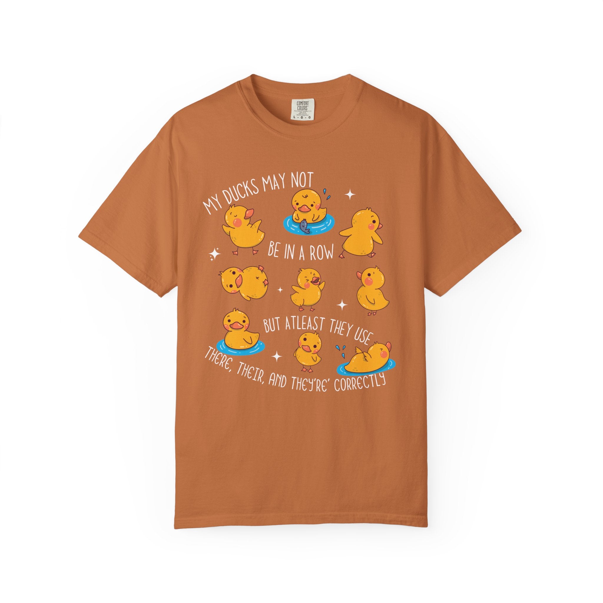 Playful duck illustration with the phrase ‘My ducks may not be in a row, but at least they use there, their, and they’re correctly,’ designed as a humorous shirt for English teachers.