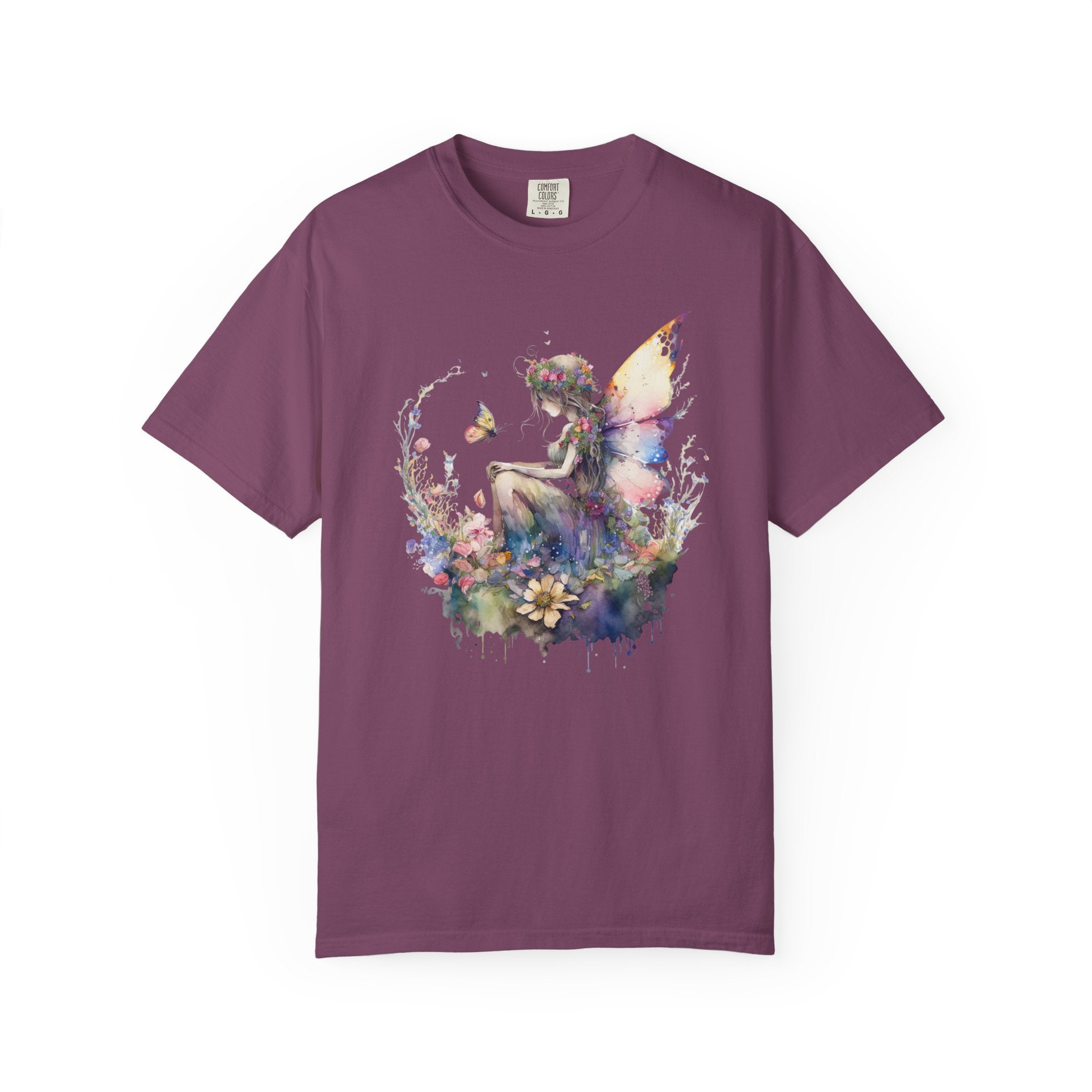 A short-sleeve crewneck t-shirt in a muted plum purple color, featuring a colorful watercolor-style graphic of a fairy surrounded by flowers on the front.