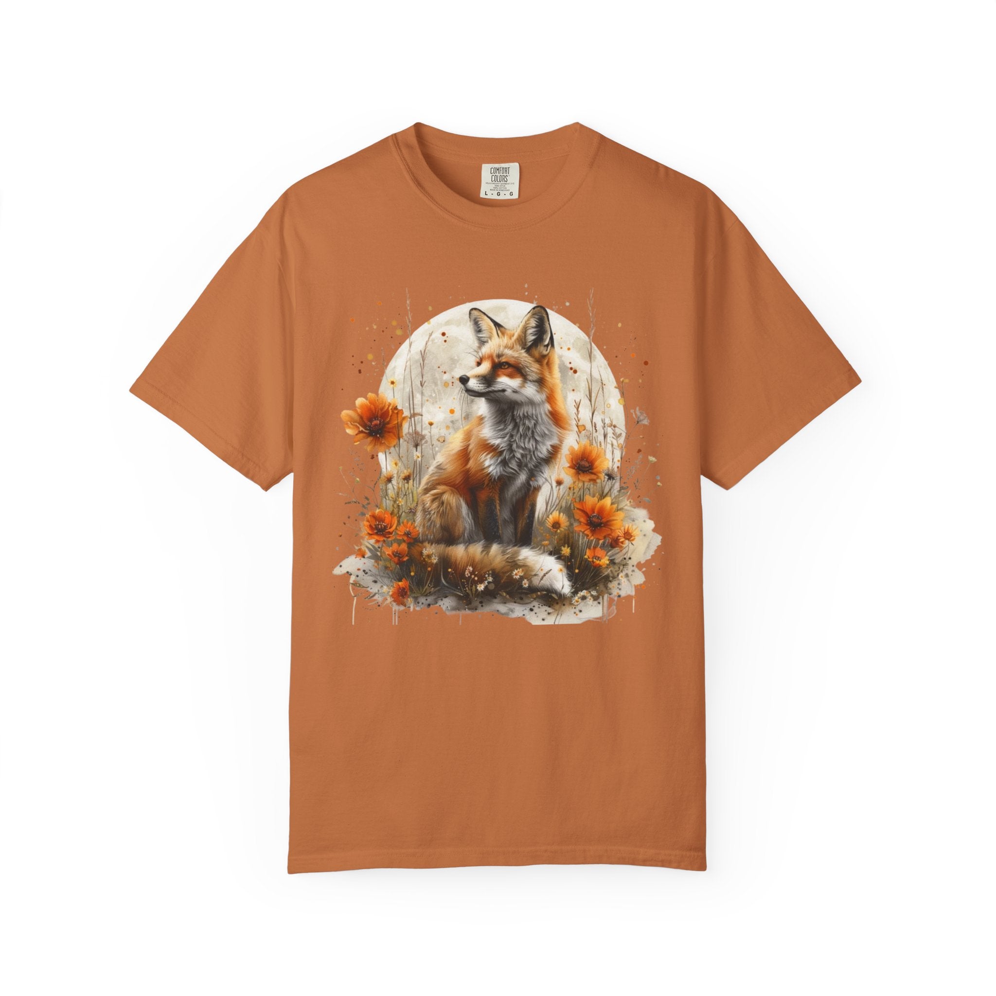 A majestic orange fox surrounded by golden wildflowers beneath a full moon on a soft Comfort Colors shirt.