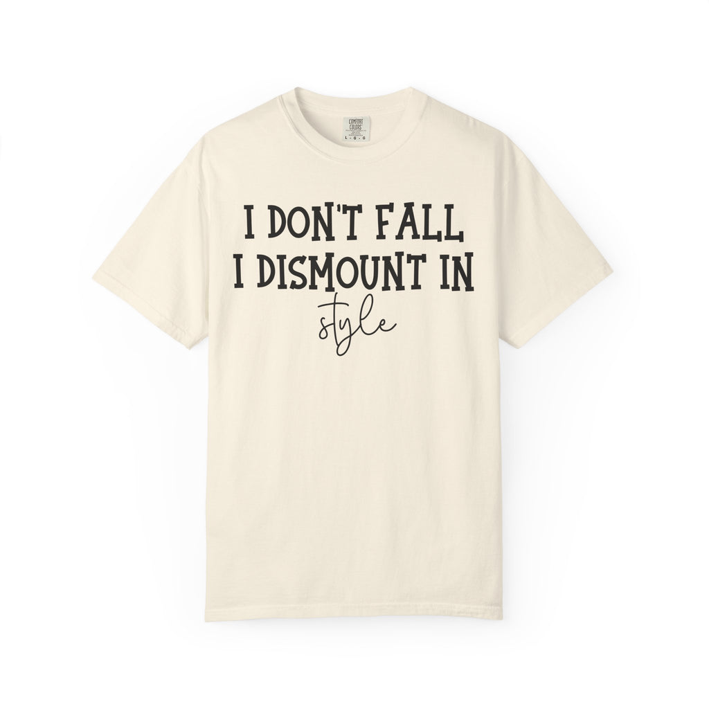 An off-white short-sleeve t-shirt with black printed text reading 'I DON'T FALL, I DISMOUNT IN style' on the front, displayed against a solid white background.