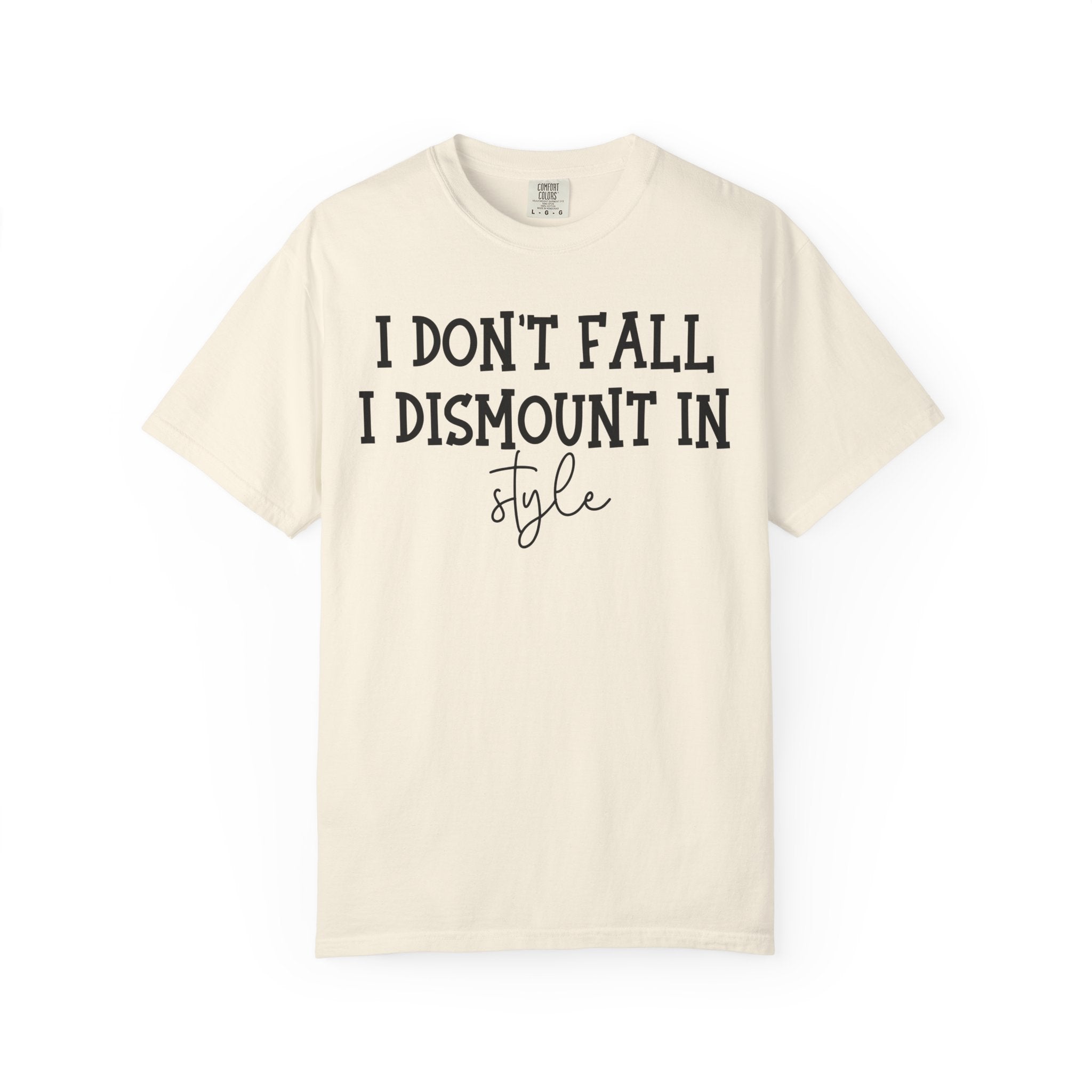 An off-white short-sleeve t-shirt with black printed text reading 'I DON'T FALL, I DISMOUNT IN style' on the front, displayed against a solid white background.