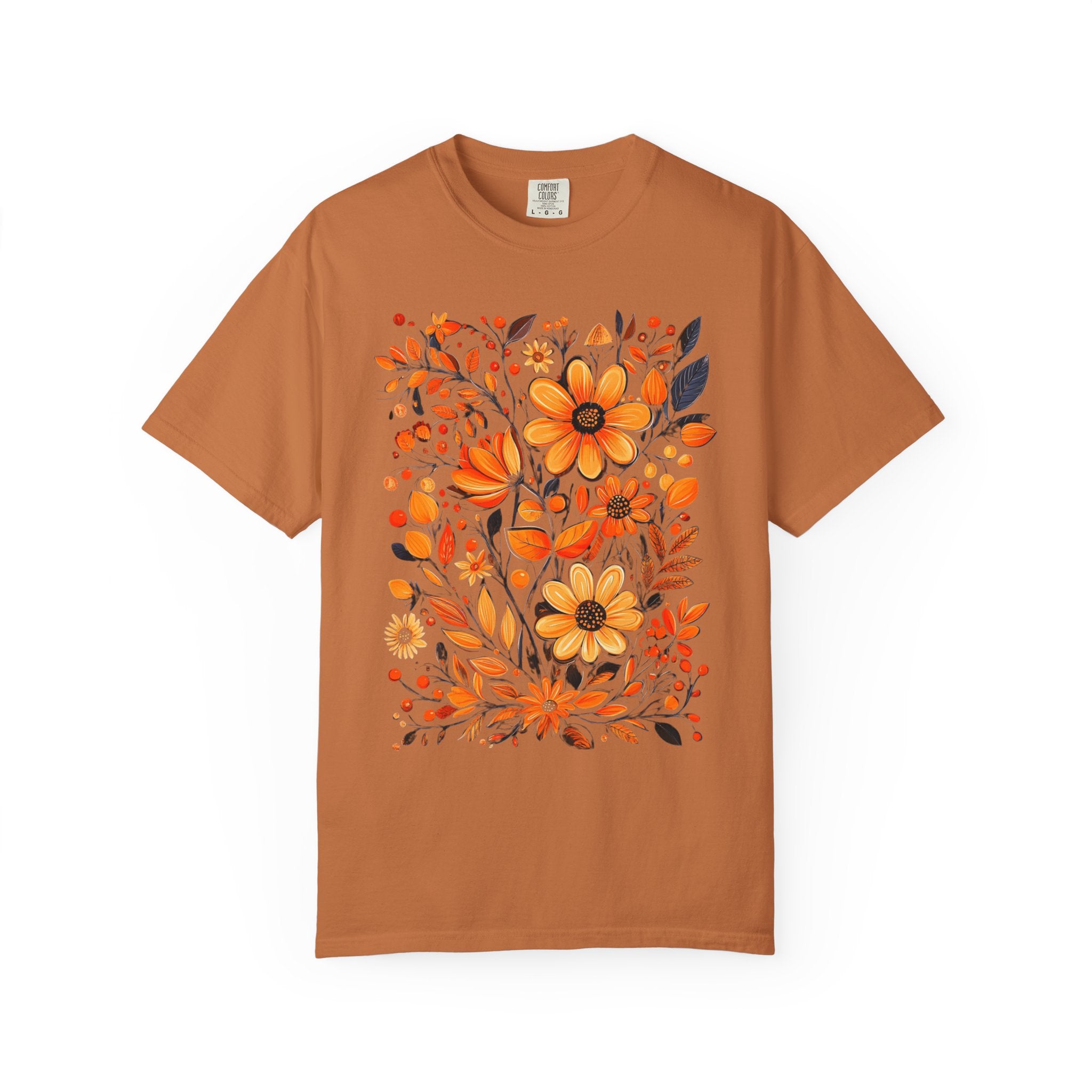 A hand-painted style floral design featuring orange and gold flowers with dark leaves, printed on a Comfort Colors cottagecore shirt.
