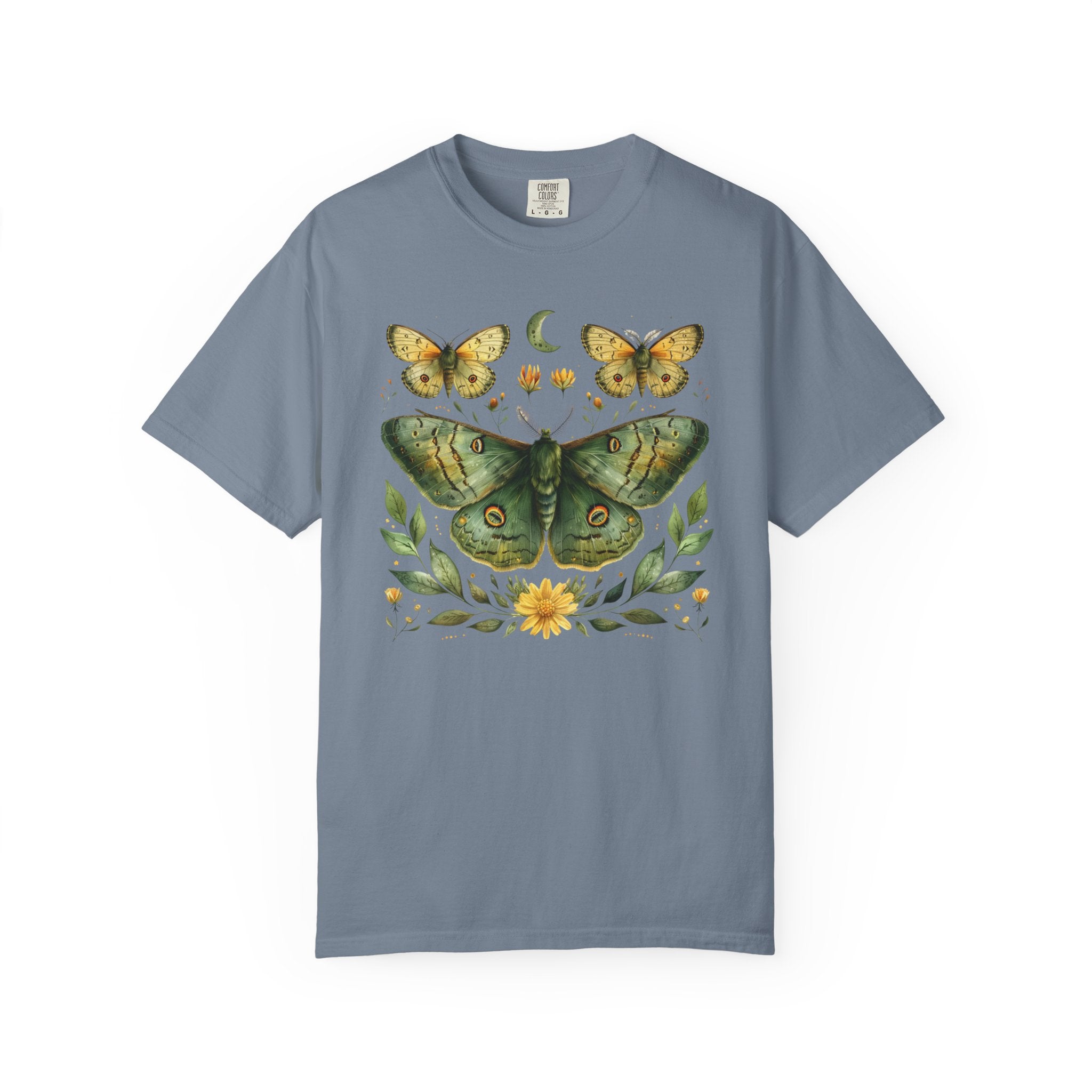 Comfort Colors graphic t-shirt featuring a detailed green luna moth surrounded by wildflowers, leaves, smaller moths, and a crescent moon in a vintage botanical cottagecore illustration