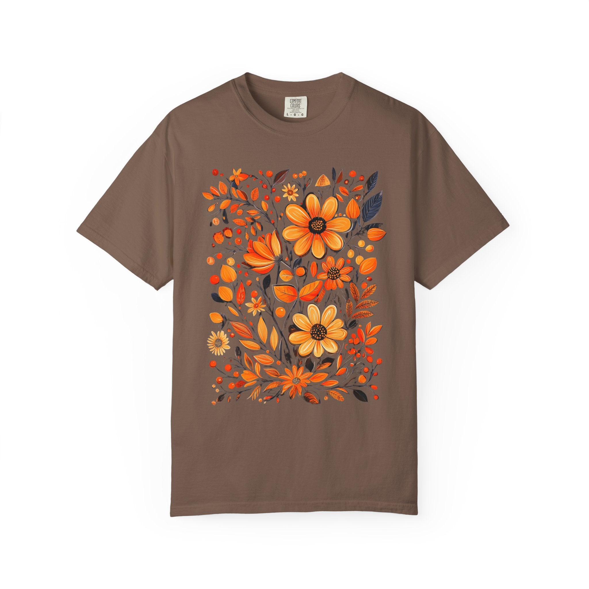 A hand-painted style floral design featuring orange and gold flowers with dark leaves, printed on a Comfort Colors cottagecore shirt.