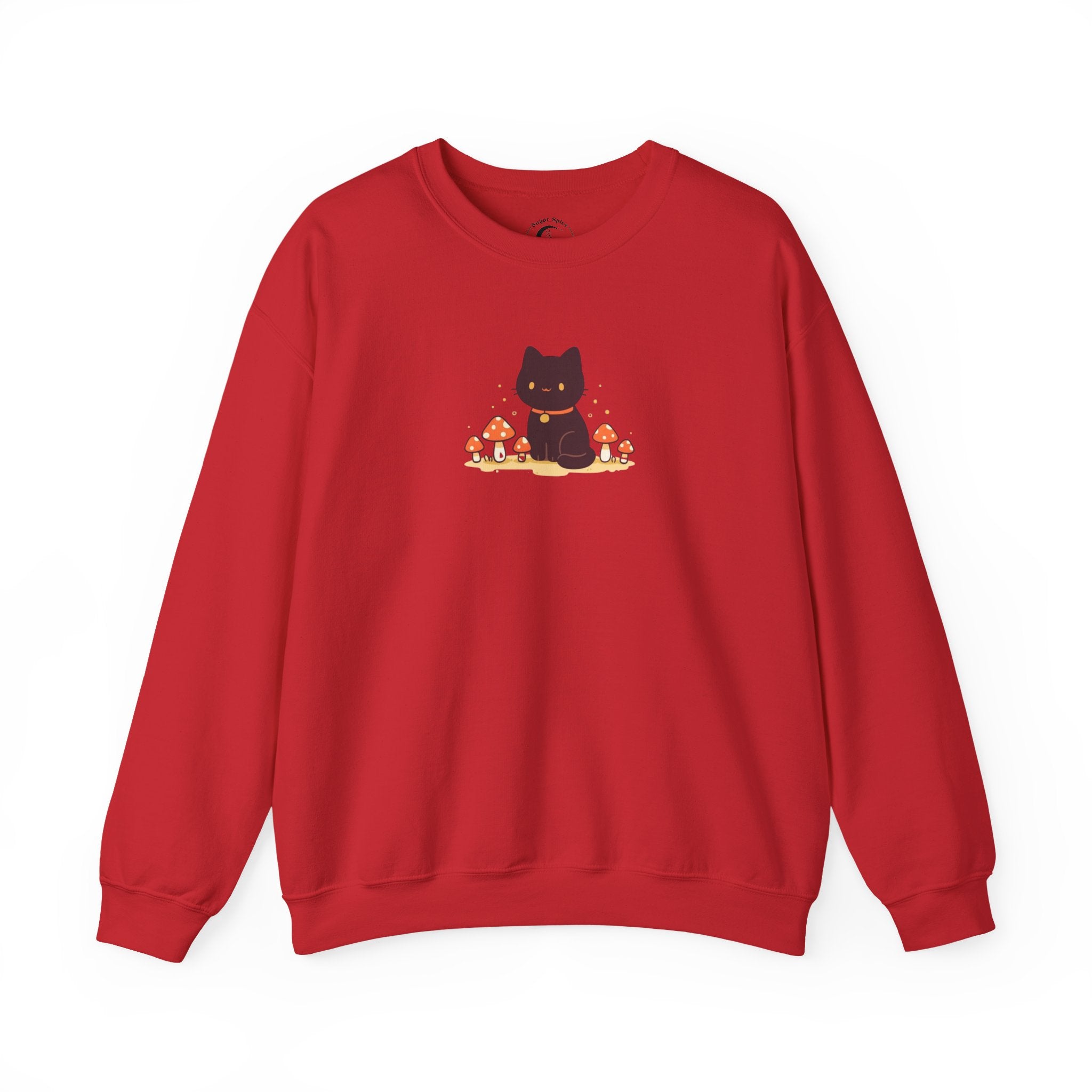 A cozy Comfort Colors sweatshirt featuring a cute black cat sitting among red mushrooms, perfect for cottagecore and witchy aesthetic lovers.