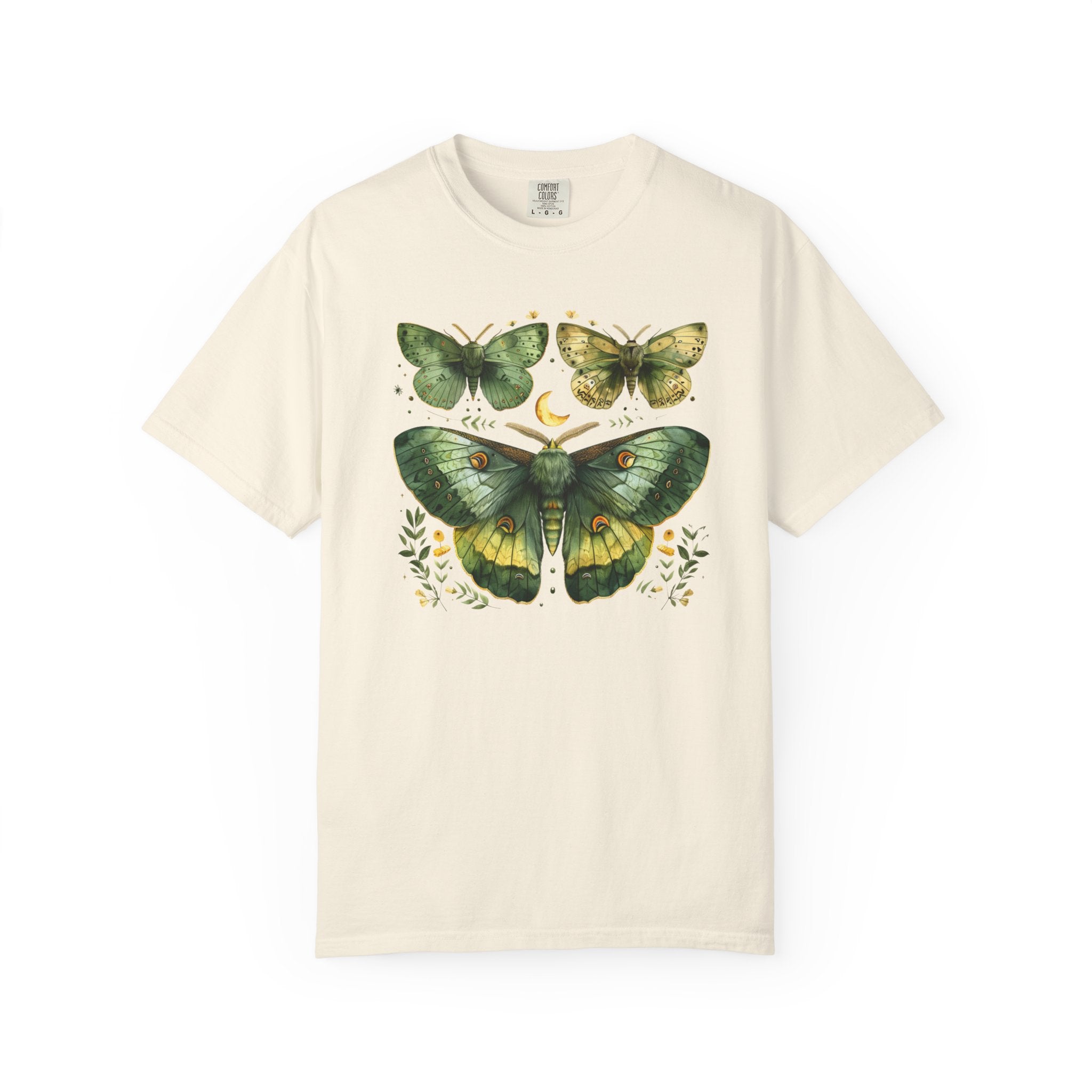 An off-white short-sleeve crewneck t-shirt featuring a vintage-style graphic print of three green and yellow moths with small floral and crescent moon details, displayed on a clean white background.