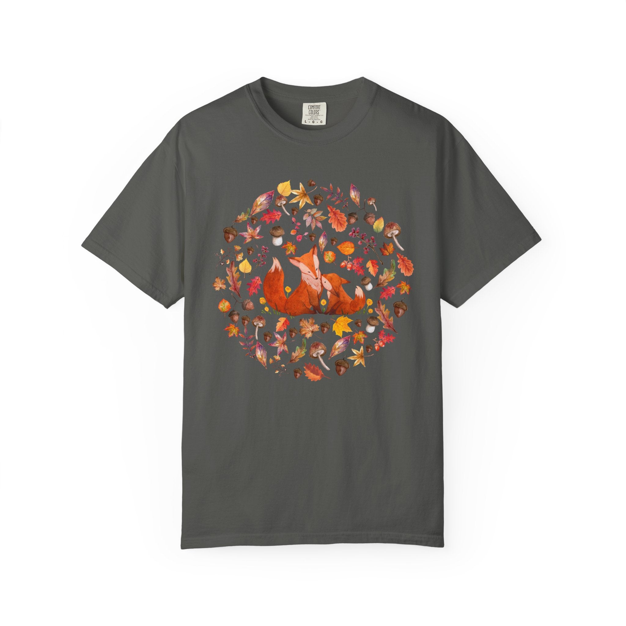 Comfort Colors ivory cottagecore shirt featuring two woodland foxes surrounded by autumn leaves, acorns, mushrooms, and forest botanicals in a whimsical watercolor style.