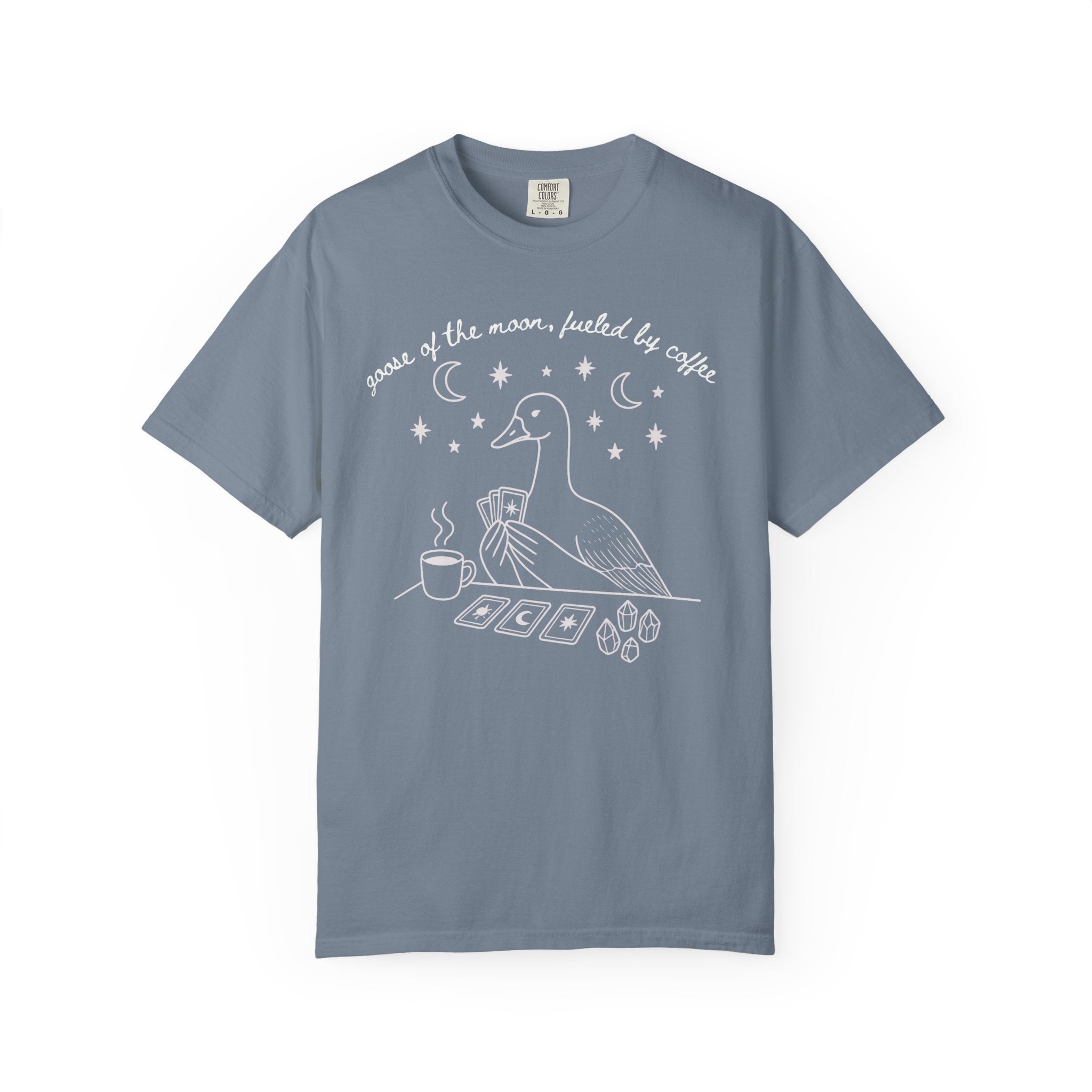 Comfort Colors t-shirt featuring a celestial goose with tarot cards, coffee cup, crystals, moons and stars and the phrase "Goose of the Moon, Fueled by Coffee."