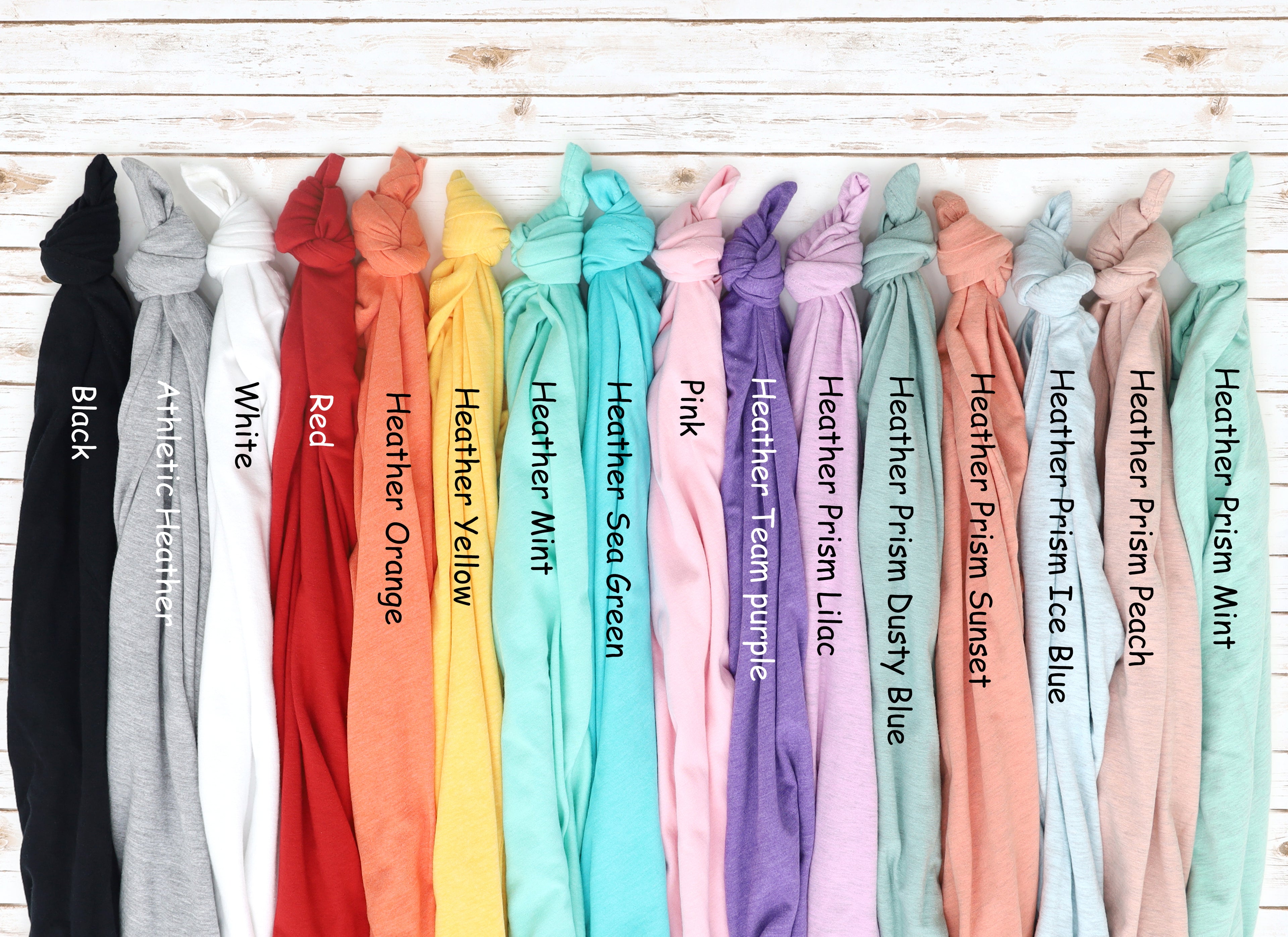 Row of colorful scarves with labels on a wooden surface