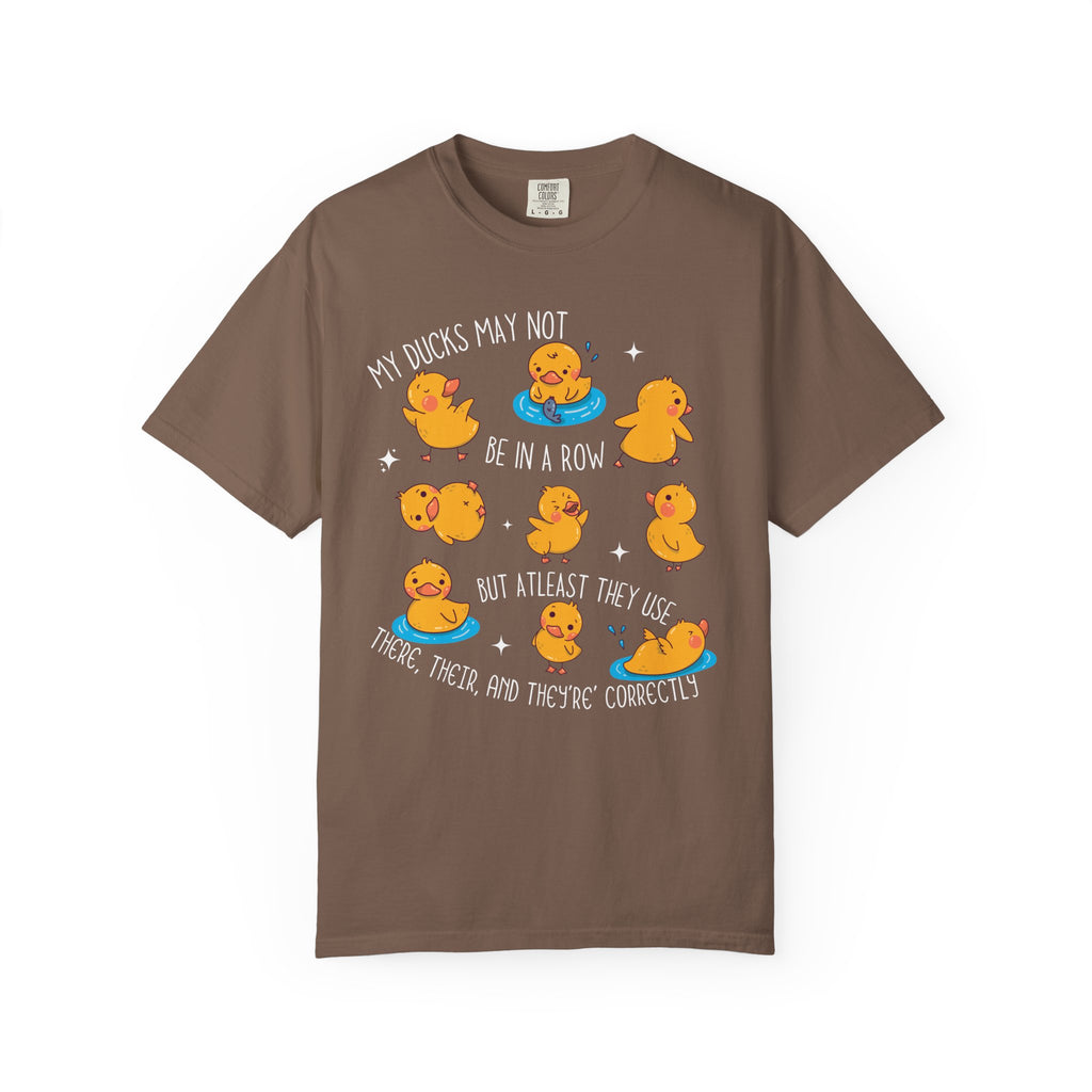 Playful duck illustration with the phrase ‘My ducks may not be in a row, but at least they use there, their, and they’re correctly,’ designed as a humorous shirt for English teachers.