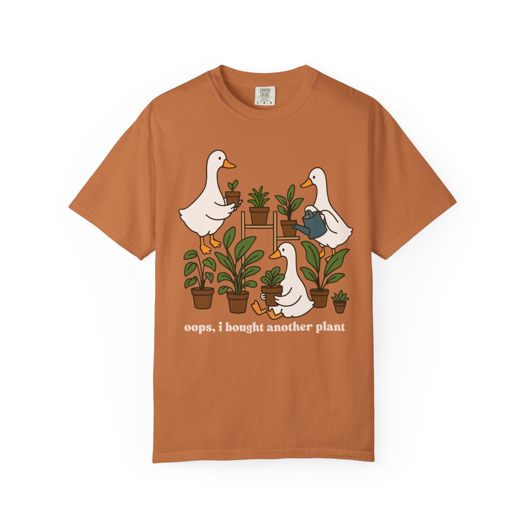 Cute shirt design featuring three geese with potted plants and the quote “Oops, I bought another plant.” Perfect for plant lovers and cottagecore style fans.