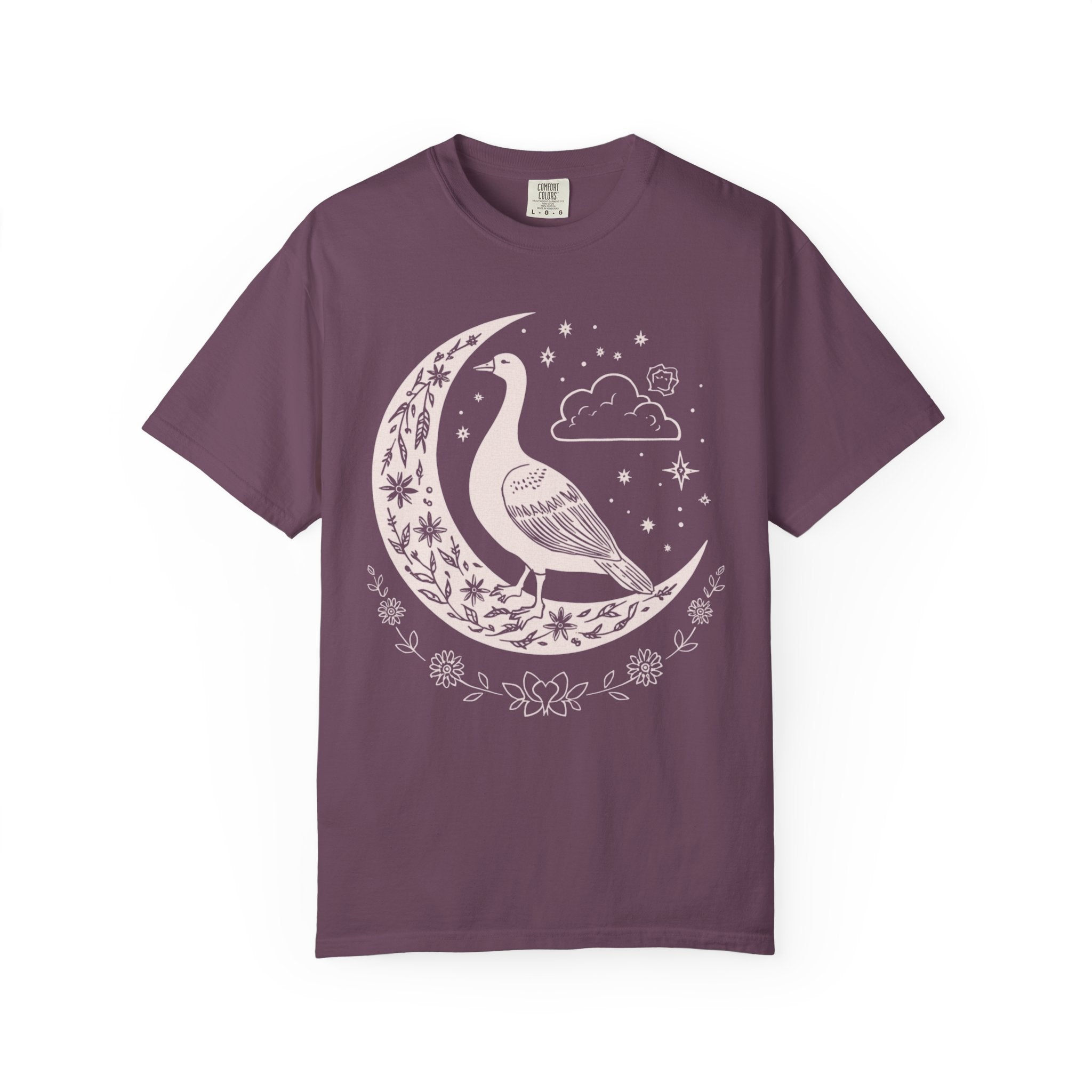 Celestial goose shirt featuring a whimsical goose on a crescent moon with stars, clouds, and floral details — witchy cottagecore design.