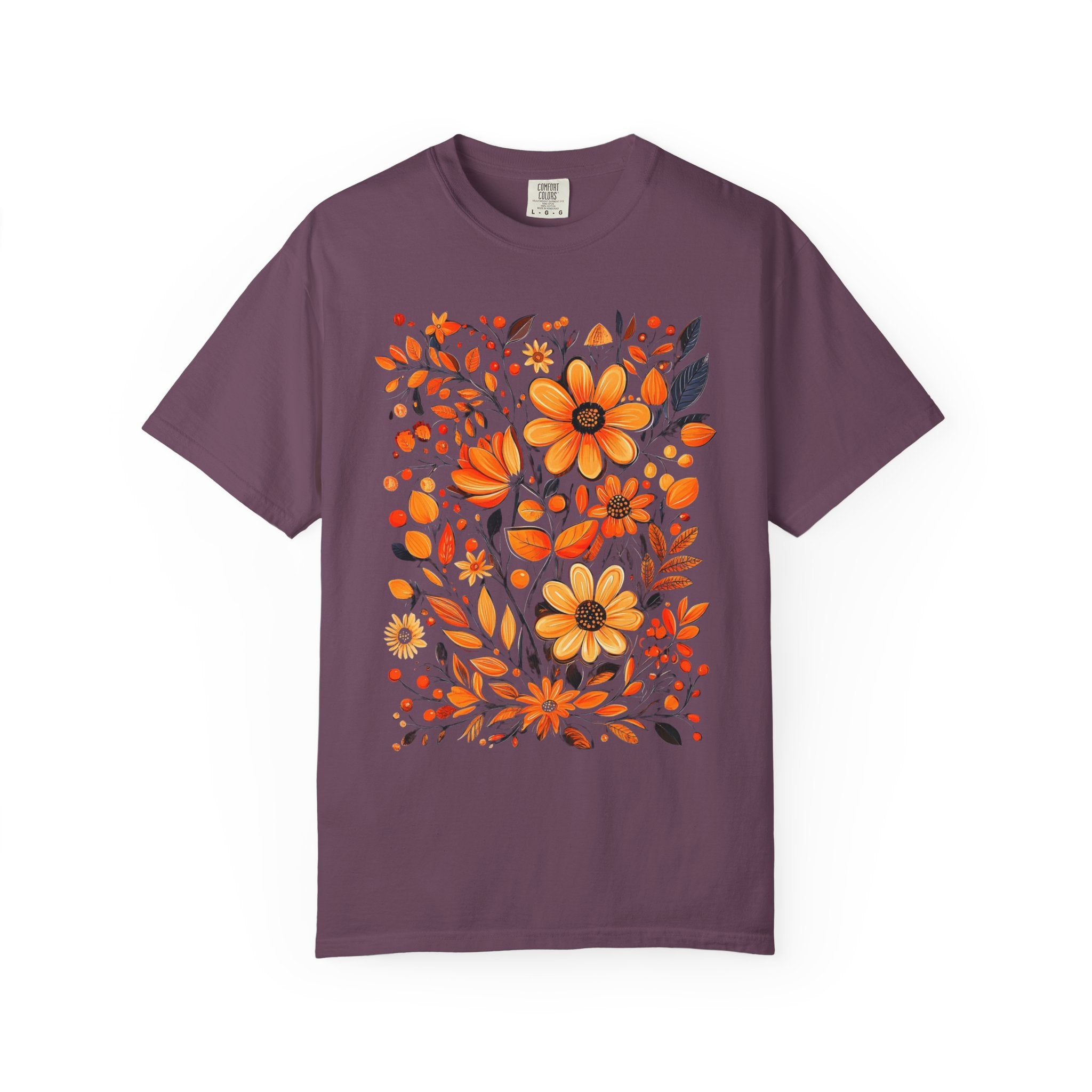 A hand-painted style floral design featuring orange and gold flowers with dark leaves, printed on a Comfort Colors cottagecore shirt.