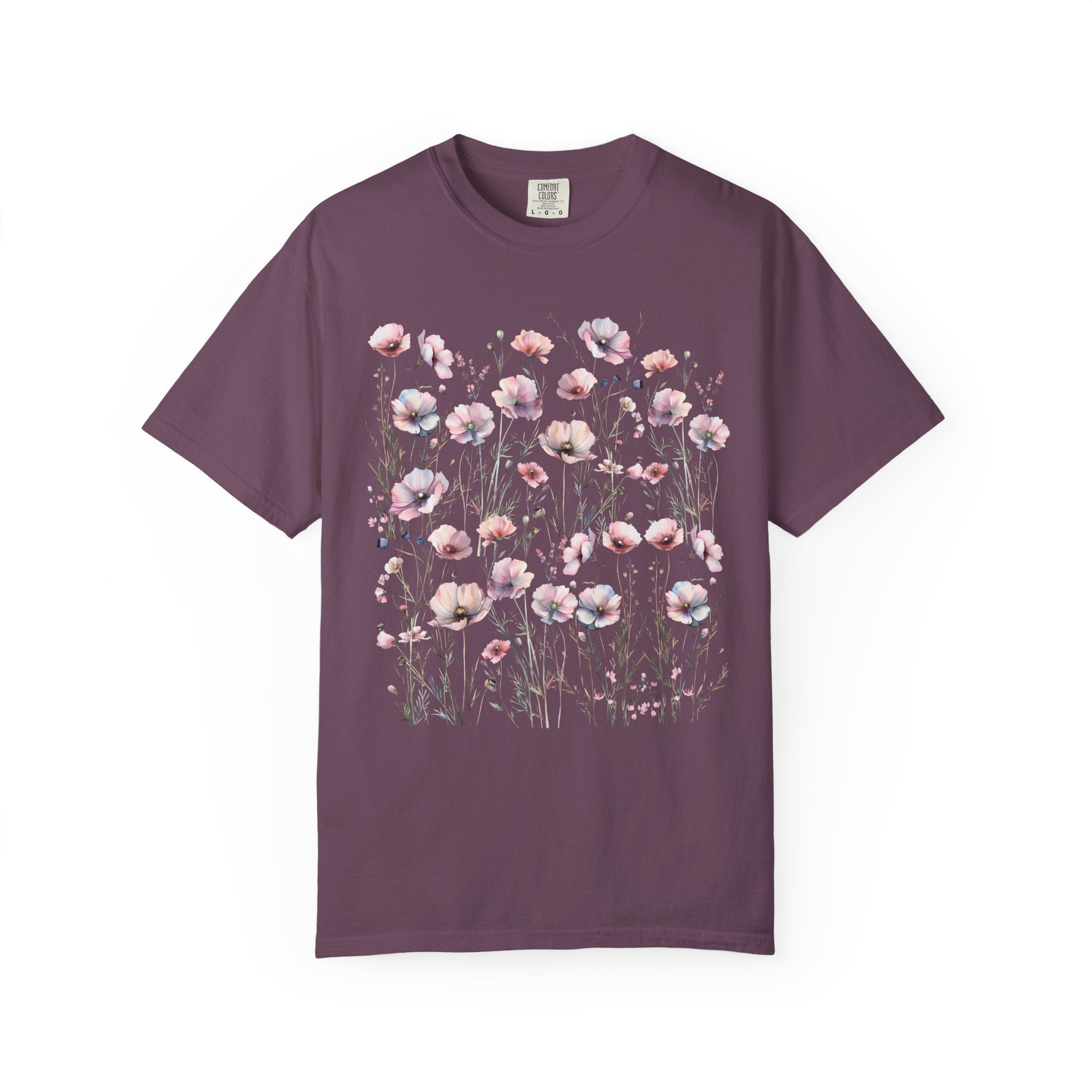 Delicate pastel wildflowers and soft pink blossoms arranged in a meadow pattern on a vintage Comfort Colors cottagecore shirt.