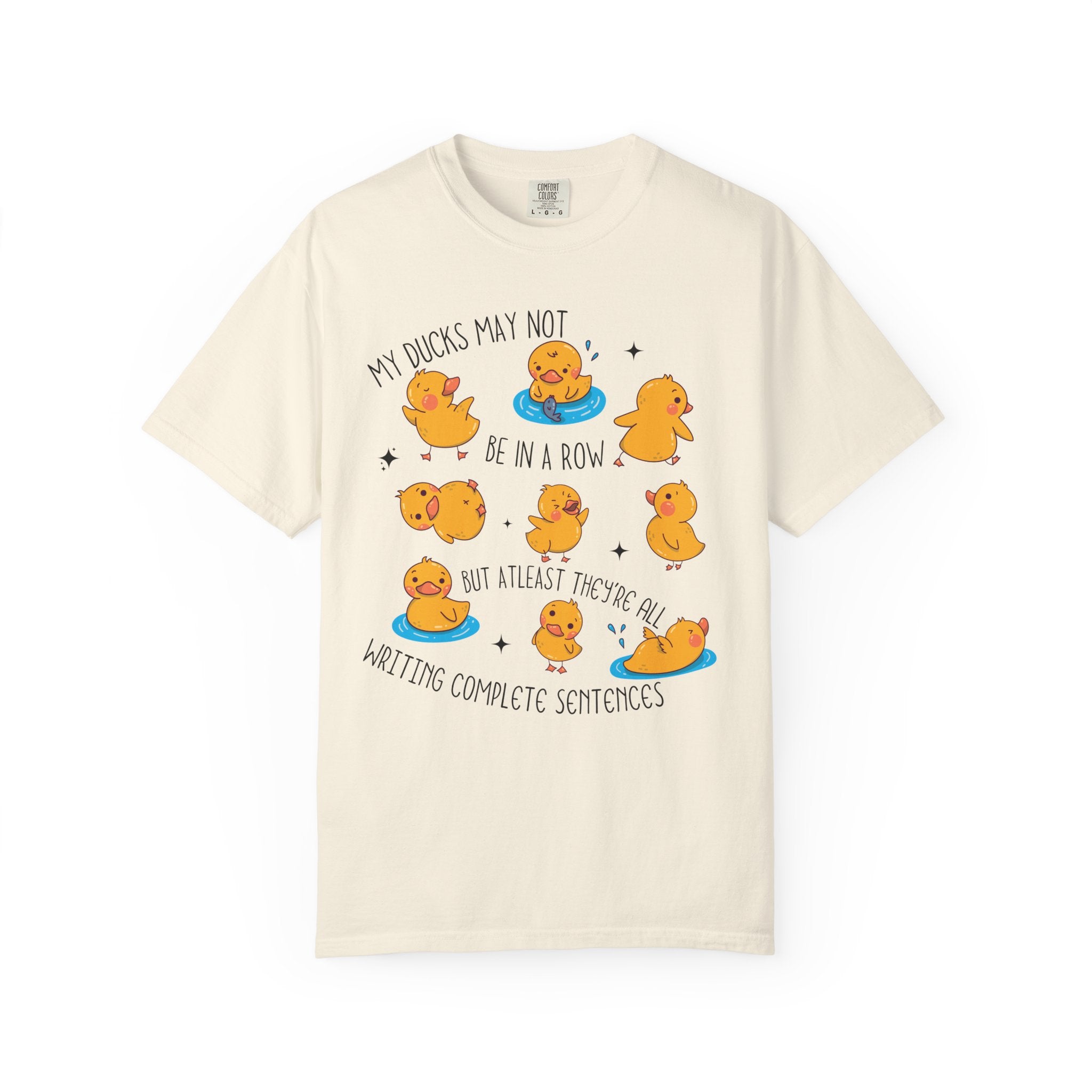 Playful duck illustration with the phrase ‘My ducks may not be in a row, but at least they’re all writing complete sentences,’ designed as a humorous shirt for English teachers.