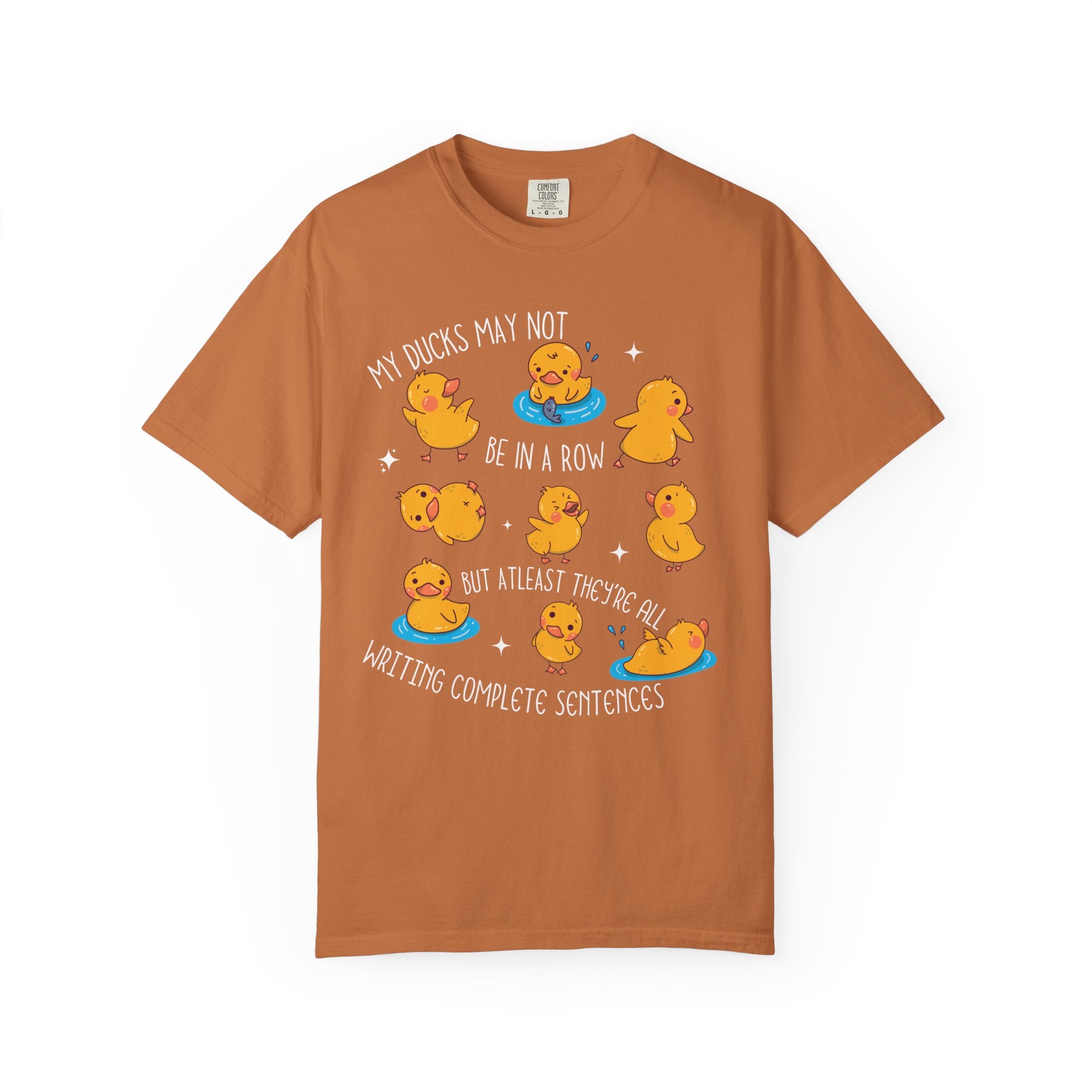 Playful duck illustration with the phrase ‘My ducks may not be in a row, but at least they’re all writing complete sentences,’ designed as a humorous shirt for English teachers.