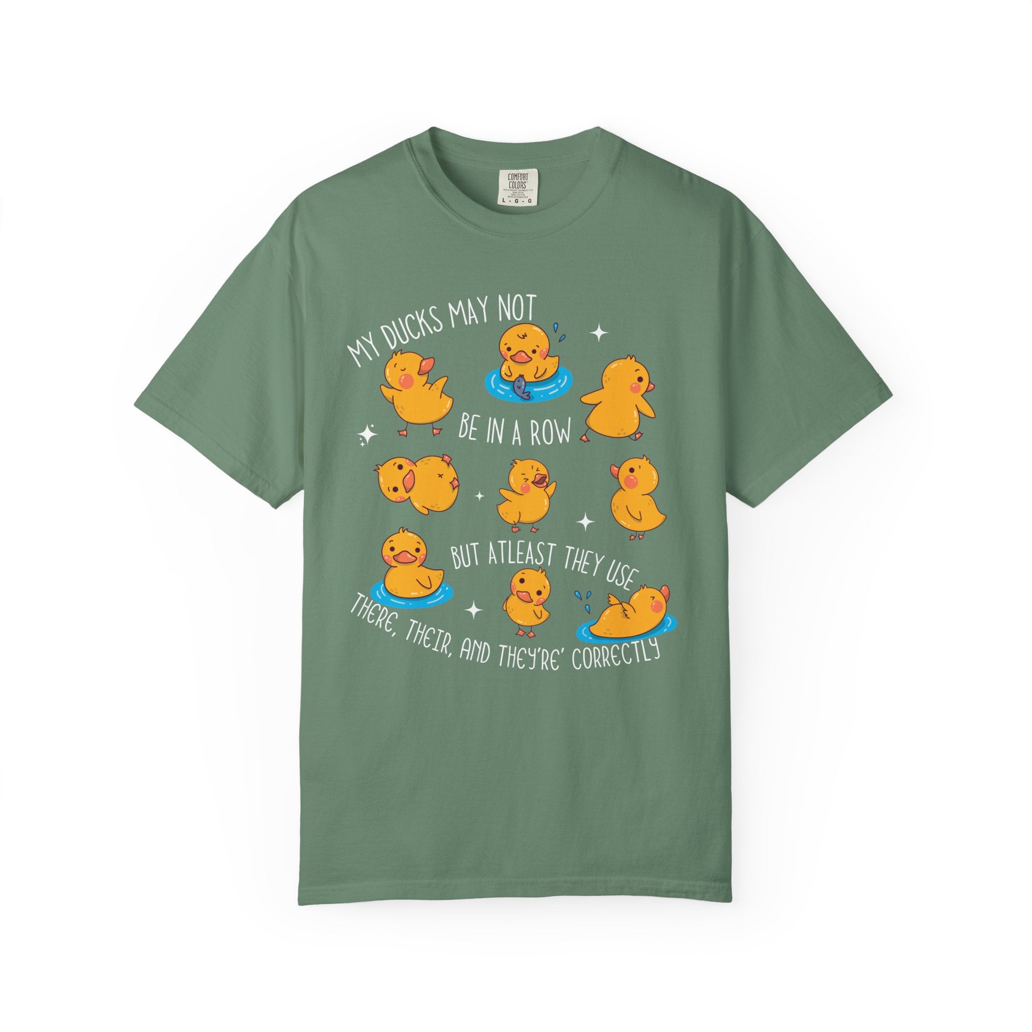 Playful duck illustration with the phrase ‘My ducks may not be in a row, but at least they use there, their, and they’re correctly,’ designed as a humorous shirt for English teachers.