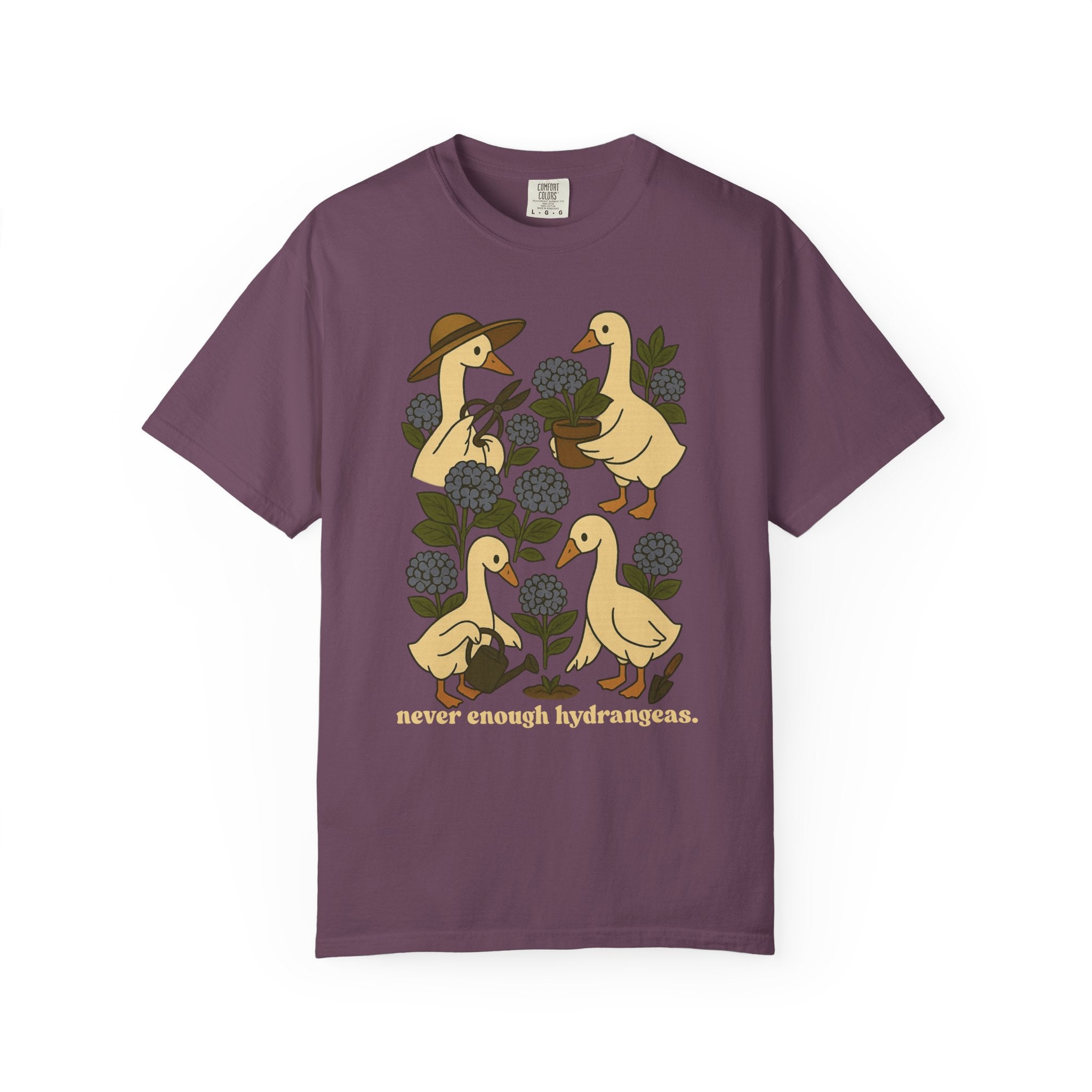 Illustration of four geese gardening among blue hydrangeas with text “never enough hydrangeas.” Cottagecore garden shirt design.