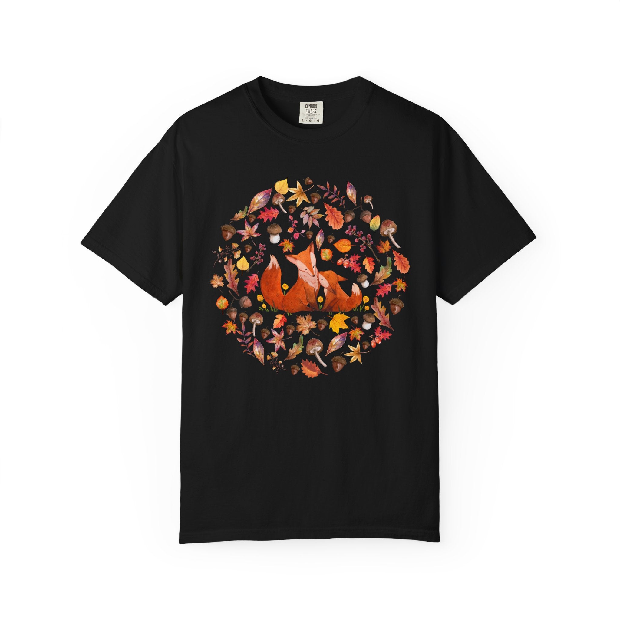 Comfort Colors ivory cottagecore shirt featuring two woodland foxes surrounded by autumn leaves, acorns, mushrooms, and forest botanicals in a whimsical watercolor style.