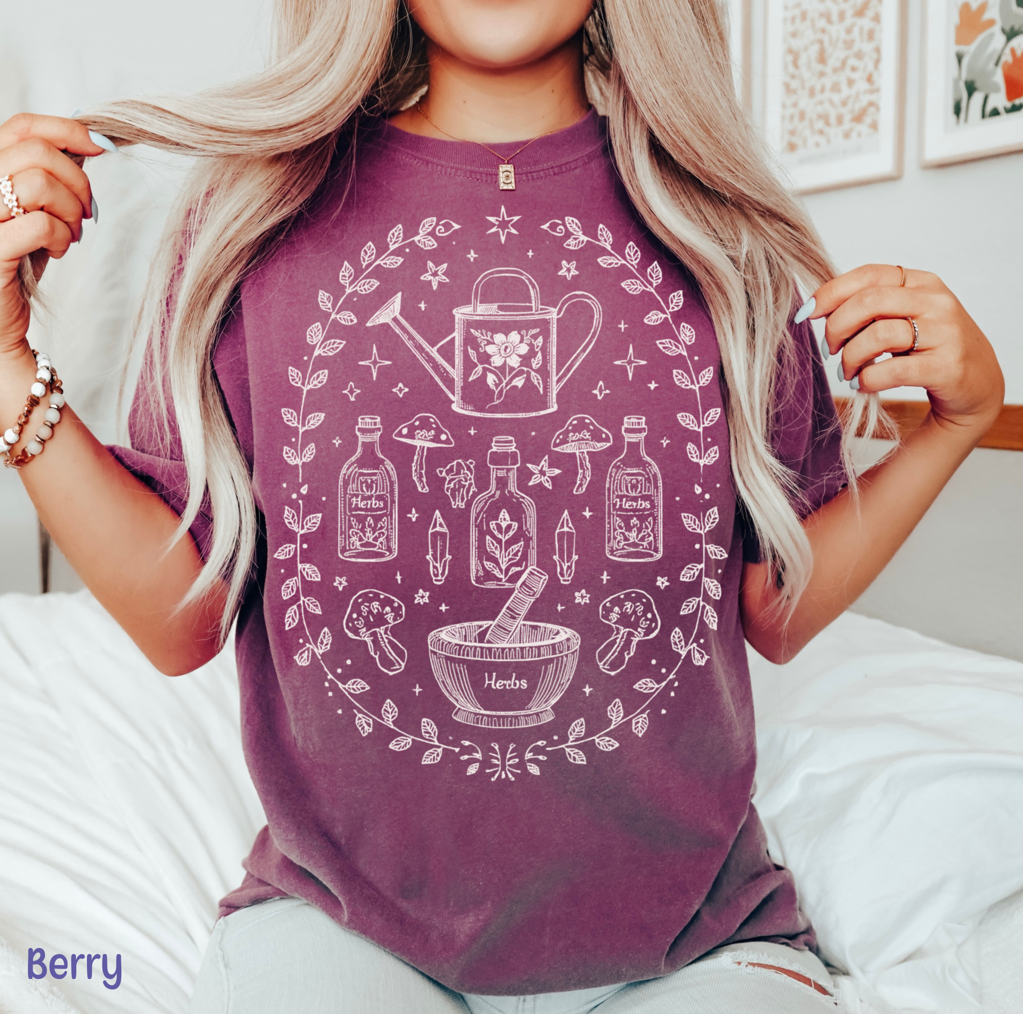Hand-drawn botanical witch t-shirt featuring vintage herb bottles, mushrooms, crystals, and watering can – mystical garden witch aesthetic design on Comfort Colors tee.