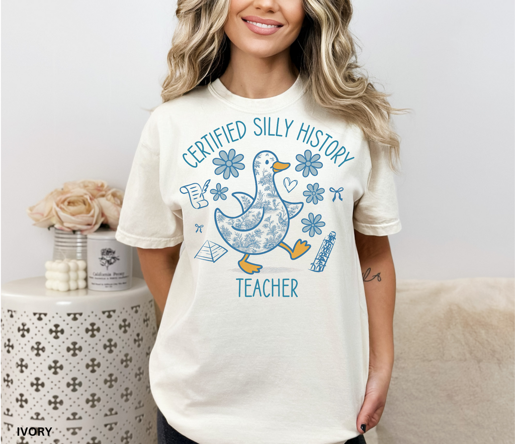 Funny history teacher shirt with a patterned goose surrounded by flowers, bows, and history doodles. Reads ‘Certified Silly History Teacher.’ Perfect classroom tee
