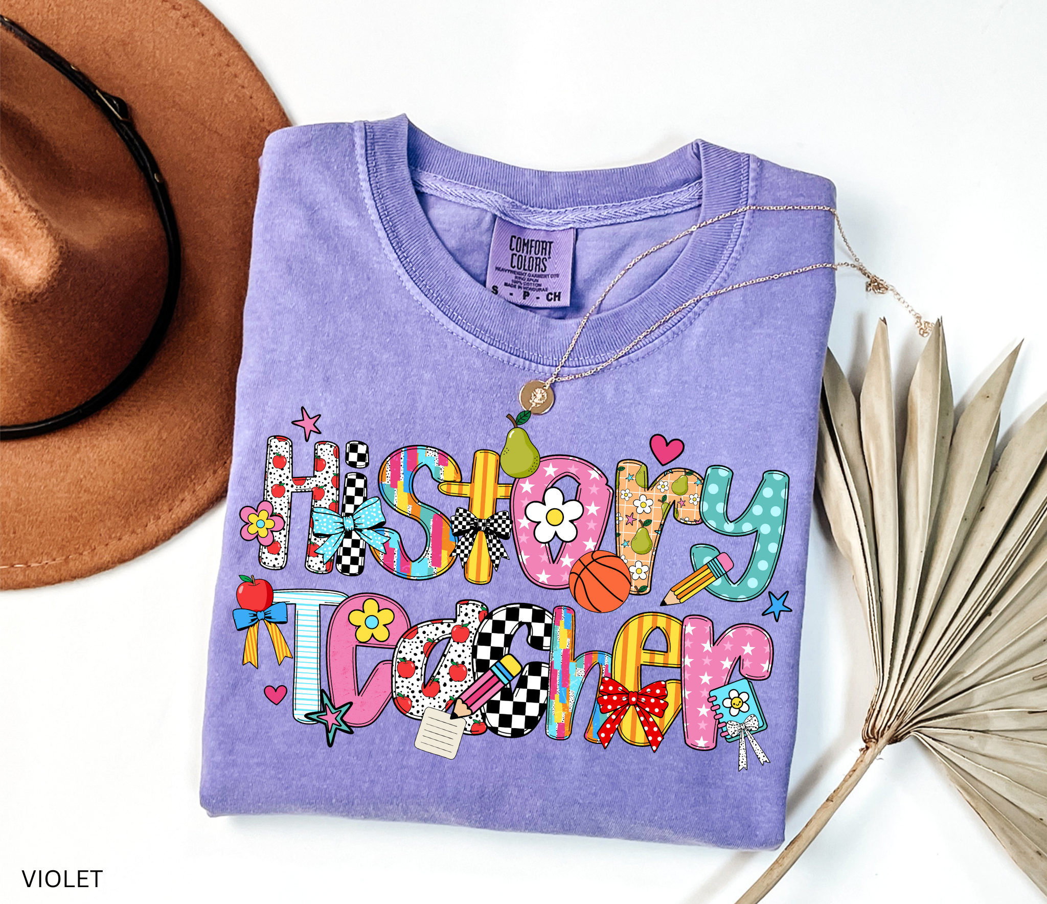 Bright and colorful shirt design with the words “History Teacher” in patchwork-style letters decorated with apples, pencils, bows, flowers, hearts, and stars. Perfect gift for teachers.