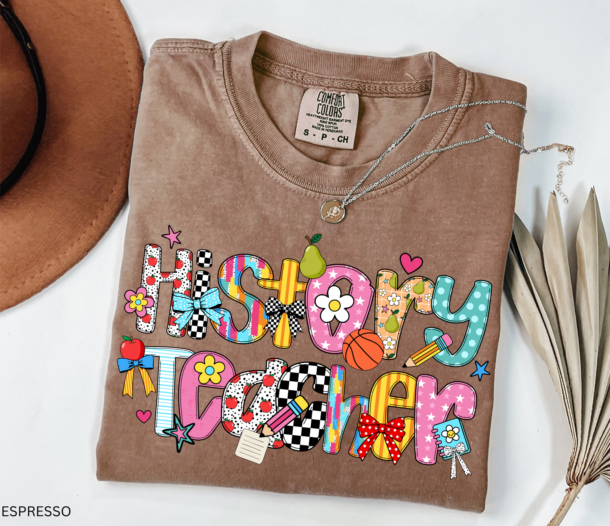 Bright and colorful shirt design with the words “History Teacher” in patchwork-style letters decorated with apples, pencils, bows, flowers, hearts, and stars. Perfect gift for teachers.