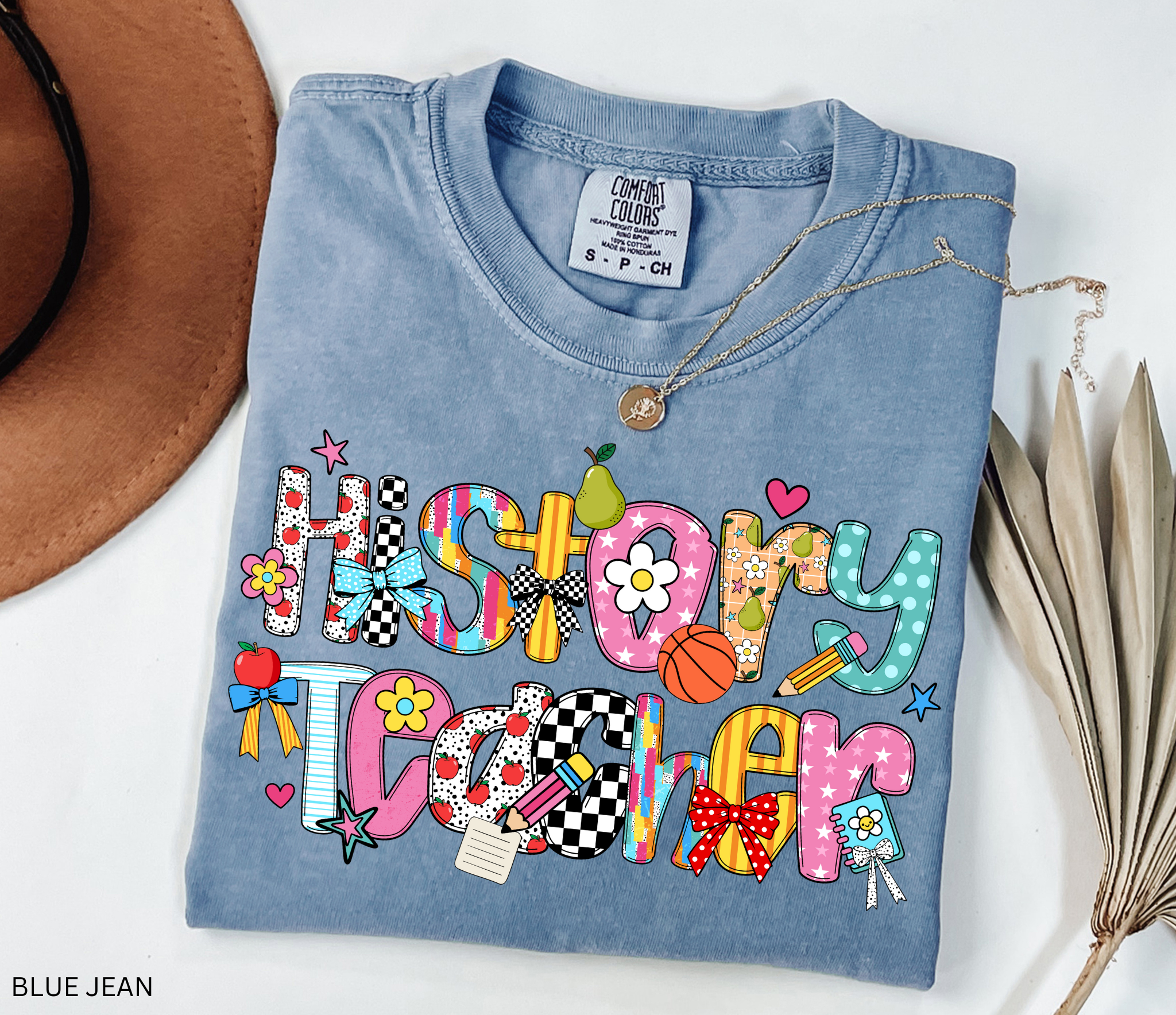 Bright and colorful shirt design with the words “History Teacher” in patchwork-style letters decorated with apples, pencils, bows, flowers, hearts, and stars. Perfect gift for teachers.