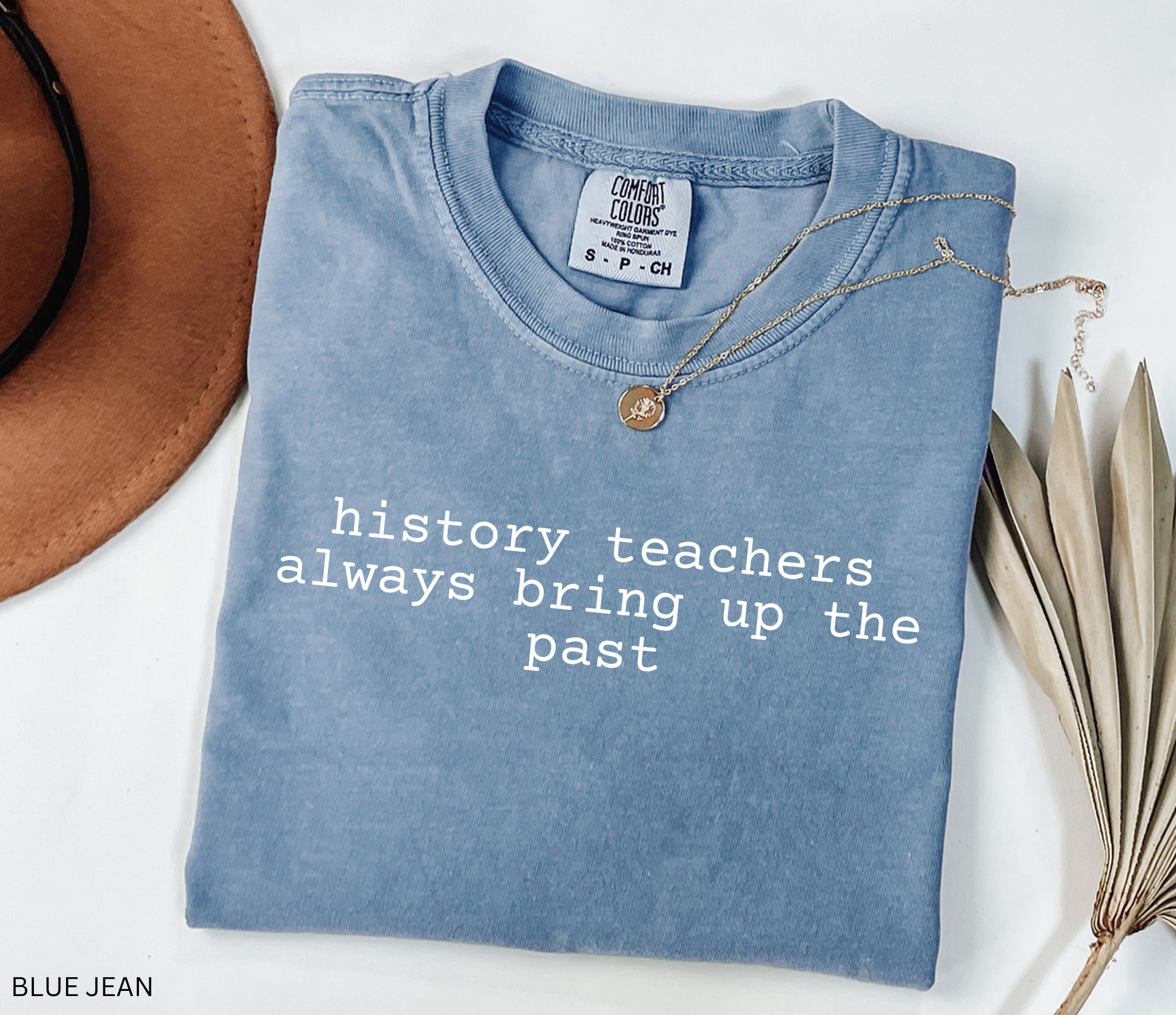 Black t-shirt design with the phrase “history teachers always bring up the past” in bold white typewriter-style font, a funny gift for history teachers.