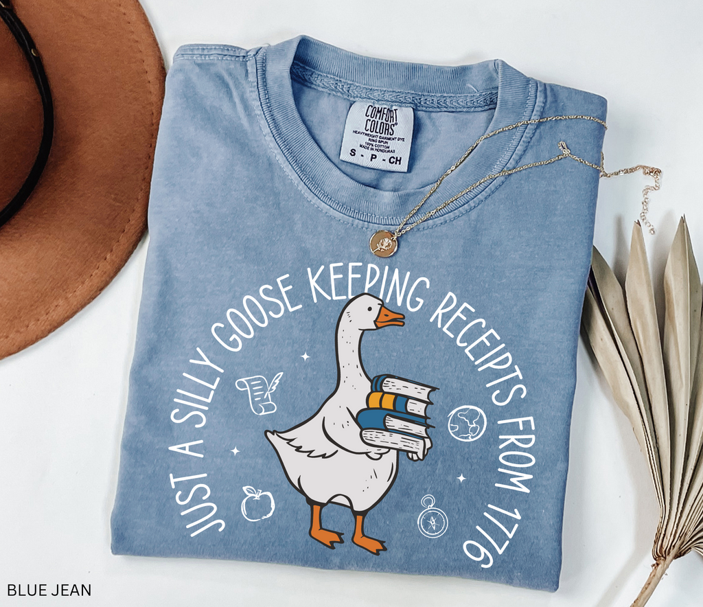 History teacher shirt with a goose holding books and the phrase ‘Just a Historical Goose Keeping Receipts from 1776.’ Funny teacher gift tee