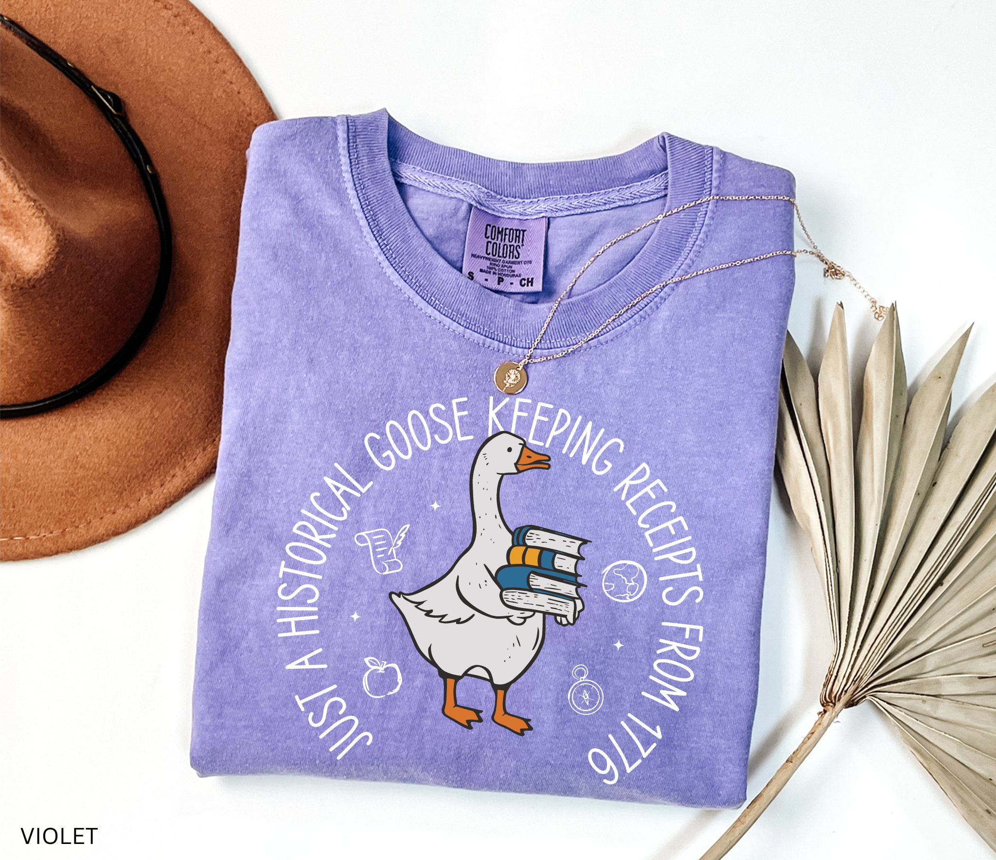 History teacher shirt with a goose holding books and the phrase ‘Just a Historical Goose Keeping Receipts from 1776.’ Funny teacher gift tee.