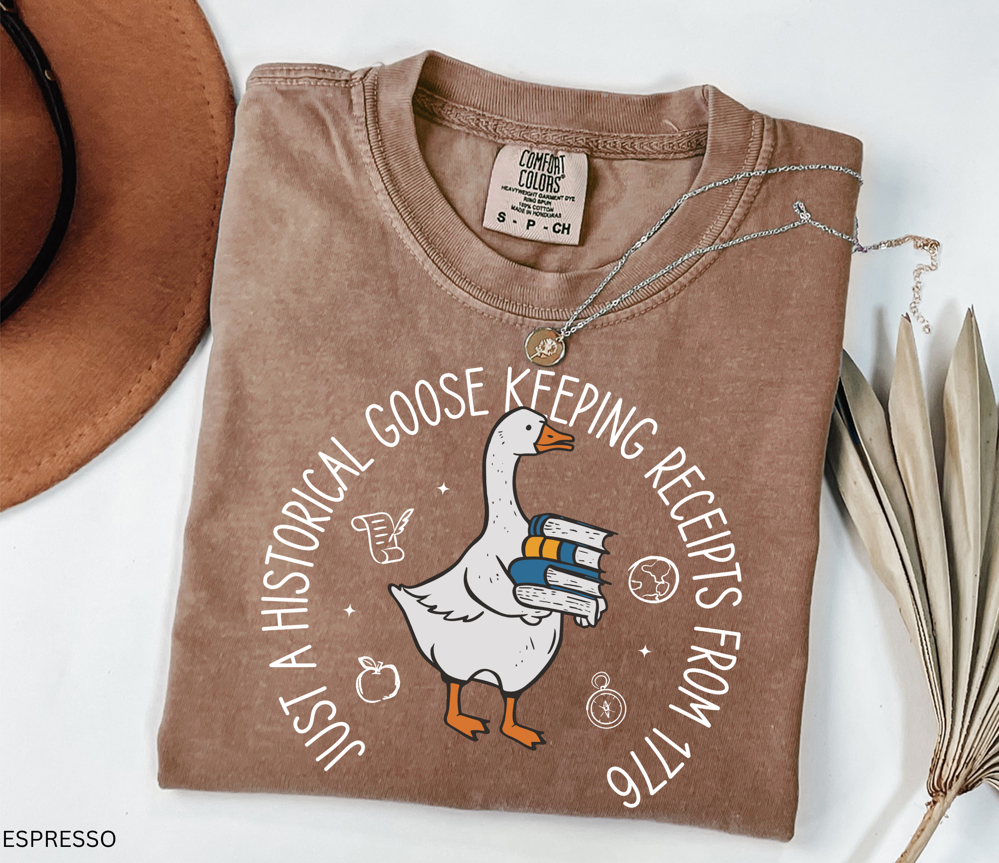 History teacher shirt with a goose holding books and the phrase ‘Just a Historical Goose Keeping Receipts from 1776.’ Funny teacher gift tee.