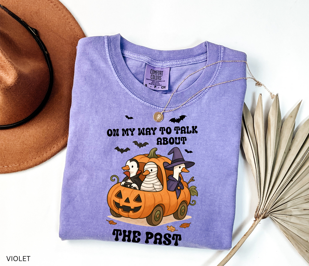 Halloween history teacher shirt with geese in a pumpkin car dressed as a witch, mummy, and vampire. Phrase reads ‘On My Way to Talk About The Past.’ Funny spooky teacher tee.