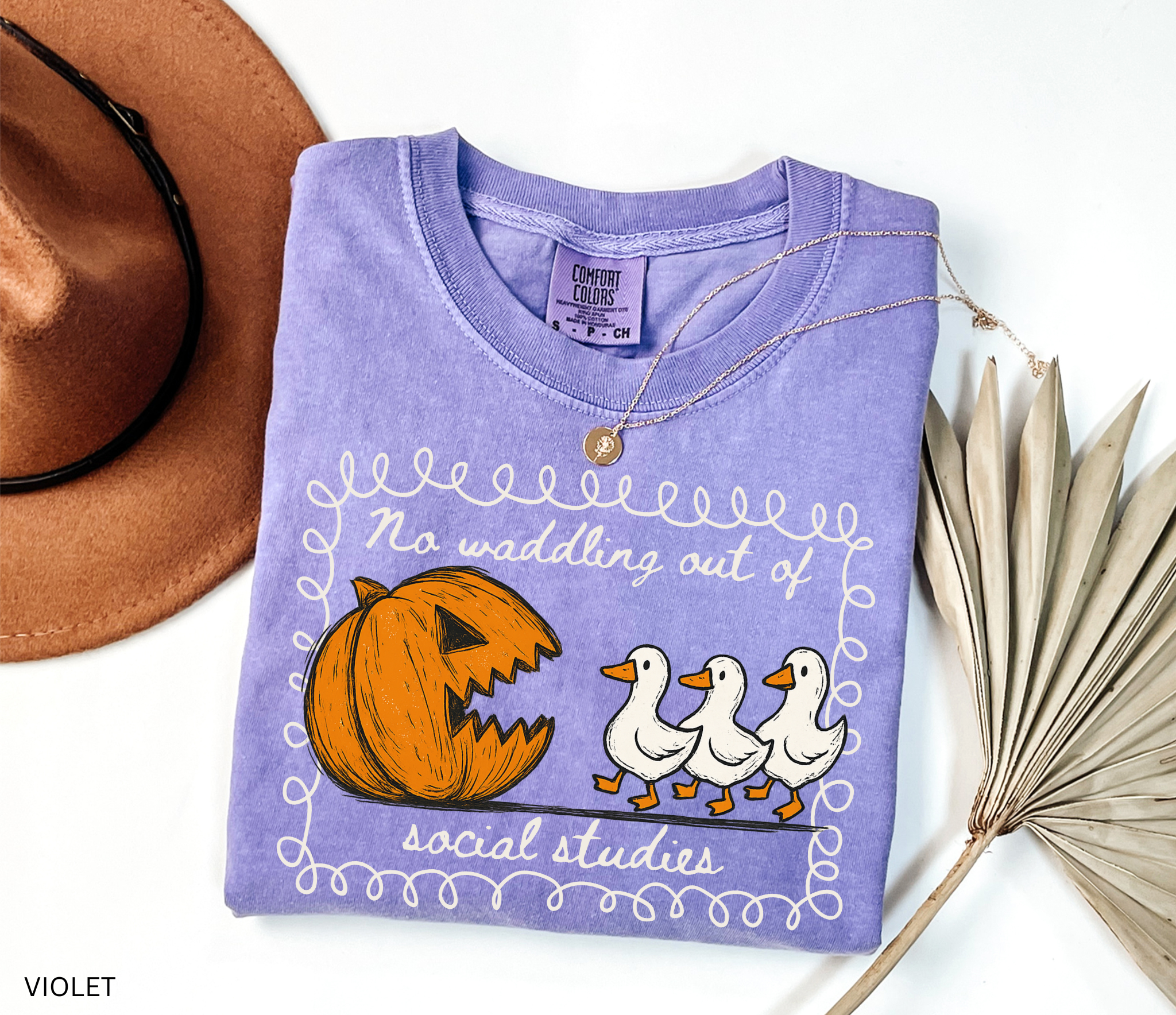 Halloween social studies teacher shirt with a pumpkin chasing geese and the phrase ‘No Waddling Out of Social Studies.’ Funny spooky season teacher tee