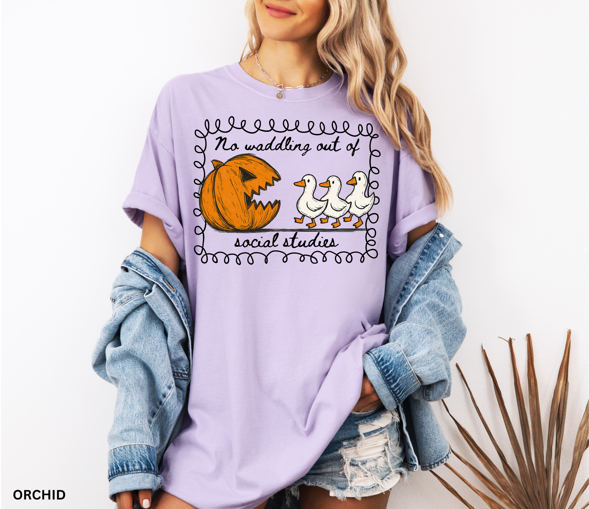 Halloween social studies teacher shirt with a pumpkin chasing geese and the phrase ‘No Waddling Out of Social Studies.’ Funny spooky season teacher tee