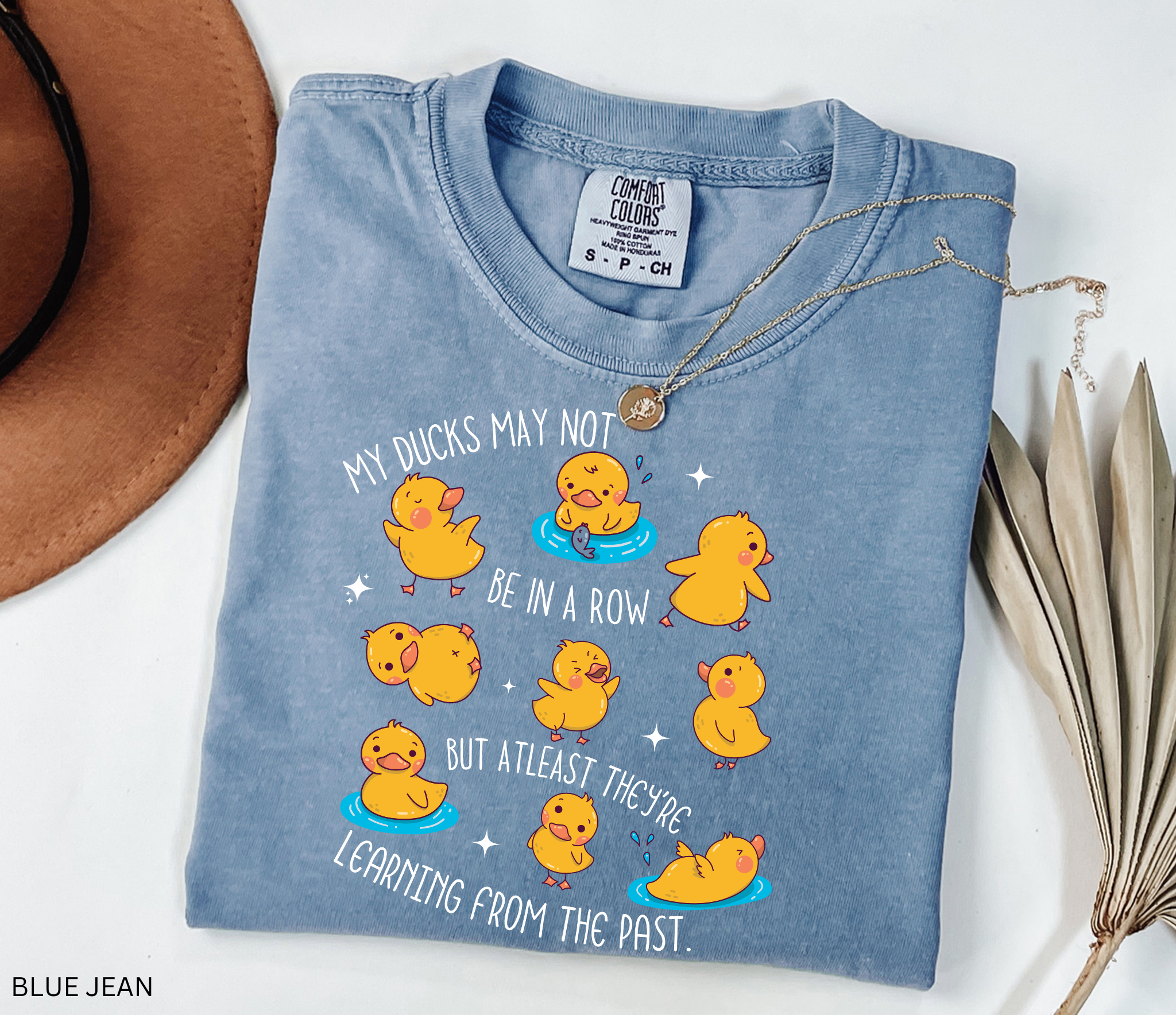 Funny history teacher shirt with yellow ducklings and the phrase ‘My ducks may not be in a row, but at least they’re learning from the past.’ Cute classroom teacher tee.