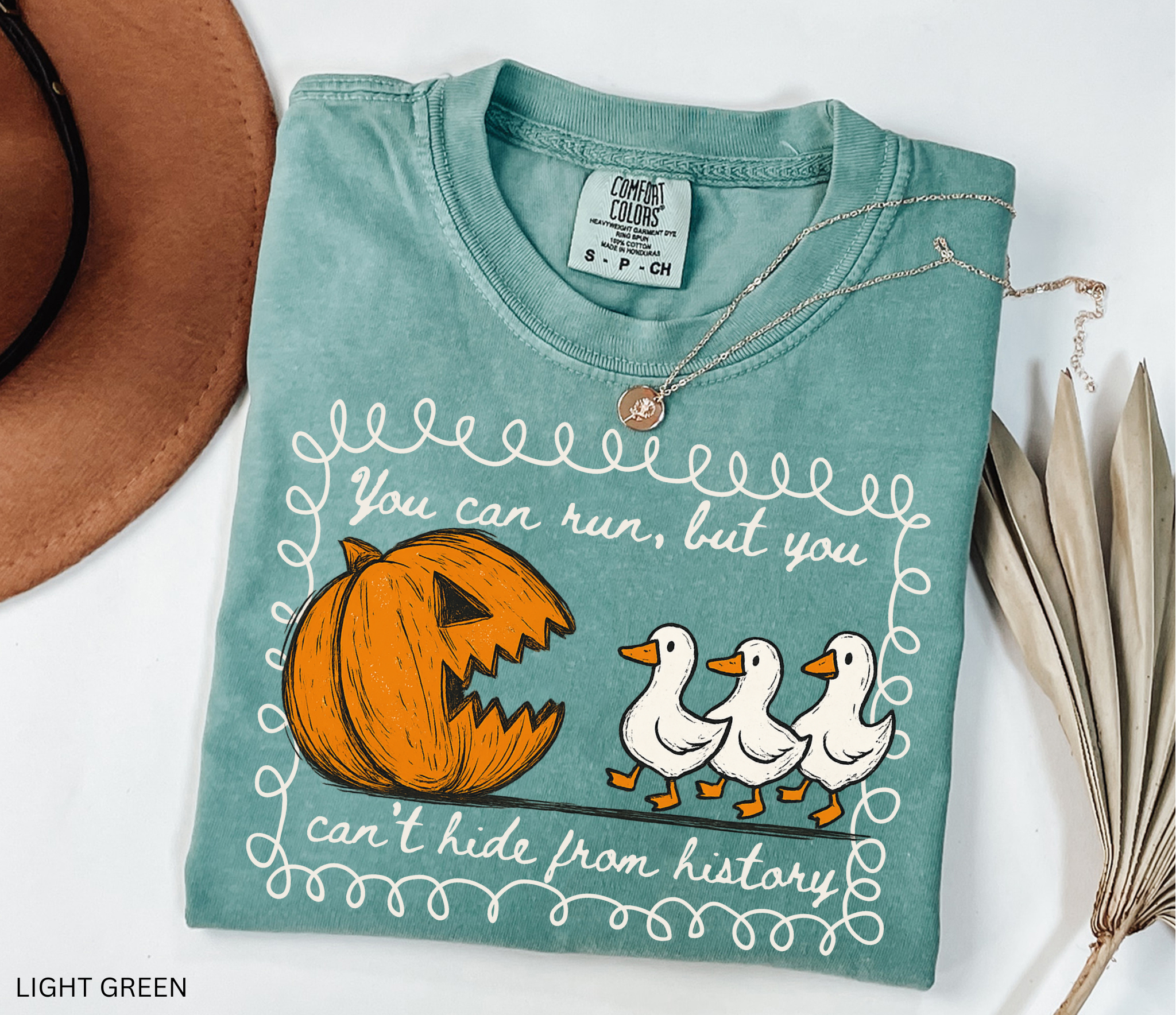 Halloween history teacher shirt with a pumpkin chasing geese and the phrase ‘You can run, but you can’t hide from history.’ Funny spooky season teacher tee