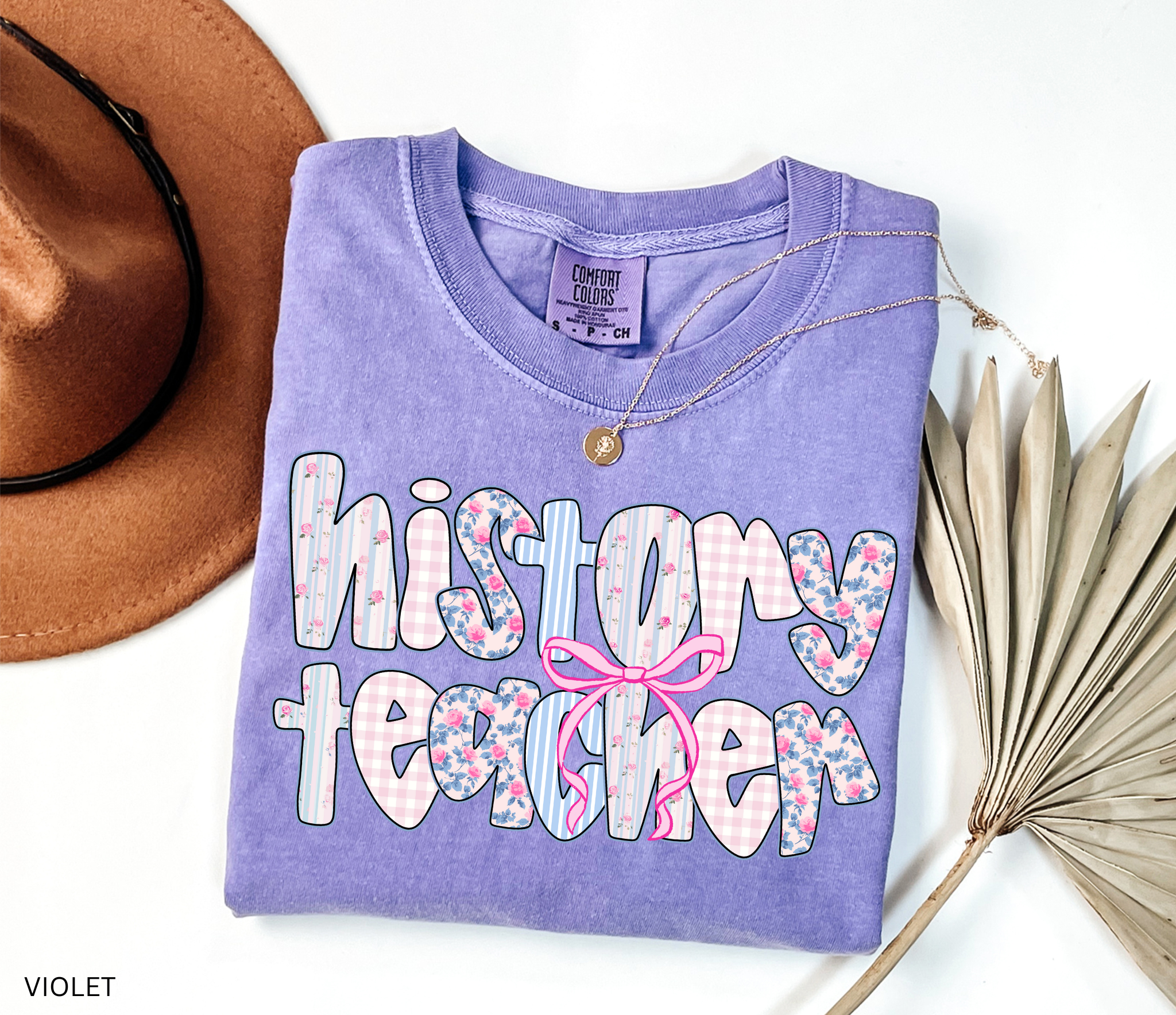 History teacher shirt with floral and gingham patchwork letters and a pink bow design. Cute and aesthetic retro-style teacher tee
