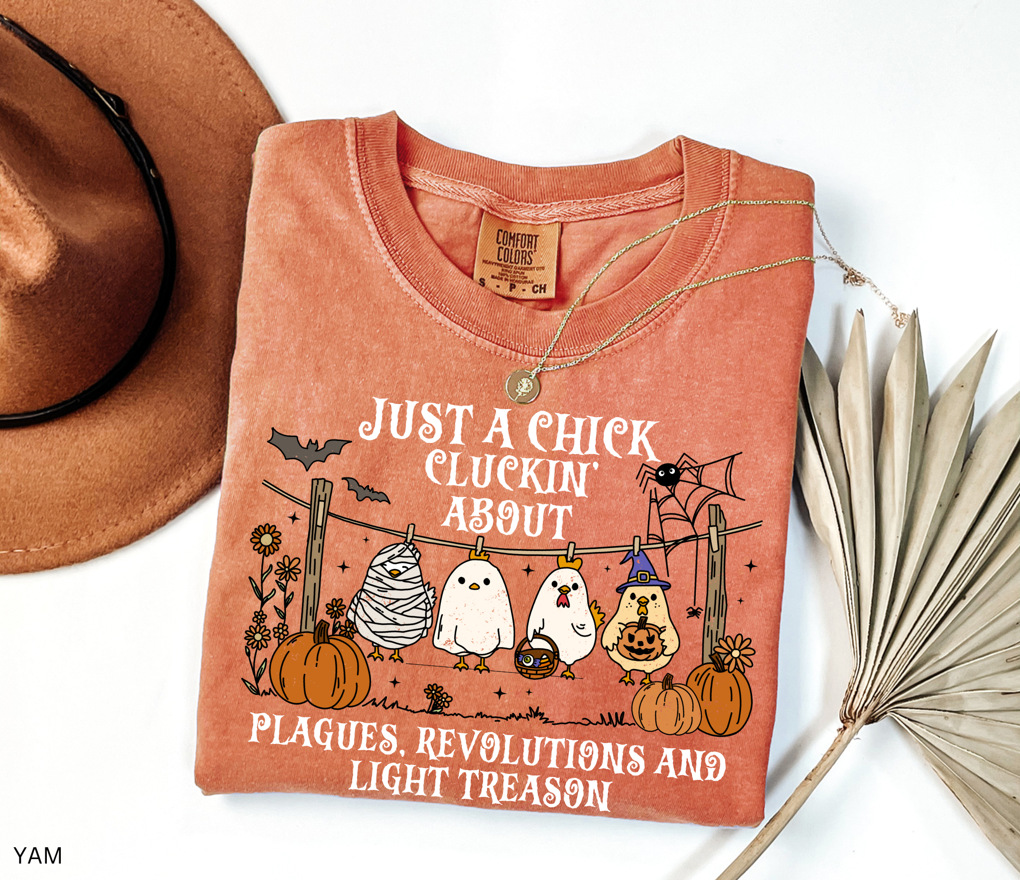 Halloween history teacher shirt with chickens in costumes, pumpkins, and text that reads ‘Just a chick cluckin’ about plagues, revolutions, and light treason.’ Funny spooky teacher tee