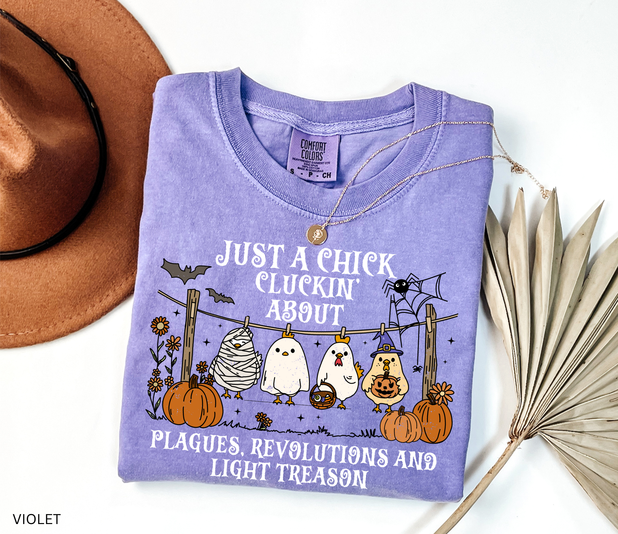 Halloween history teacher shirt with chickens in costumes, pumpkins, and text that reads ‘Just a chick cluckin’ about plagues, revolutions, and light treason.’ Funny spooky teacher tee