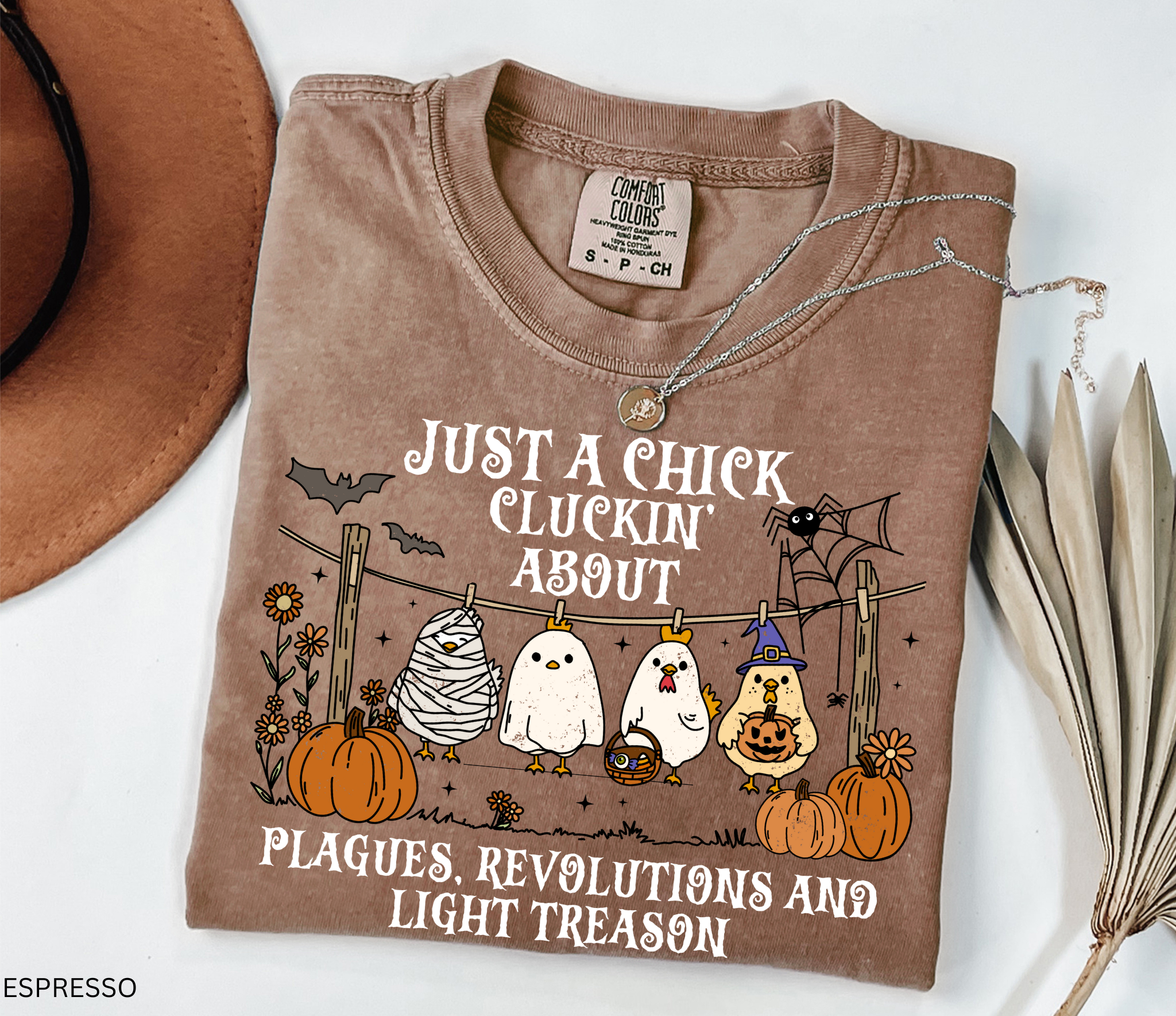 Halloween history teacher shirt with chickens in costumes, pumpkins, and text that reads ‘Just a chick cluckin’ about plagues, revolutions, and light treason.’ Funny spooky teacher tee